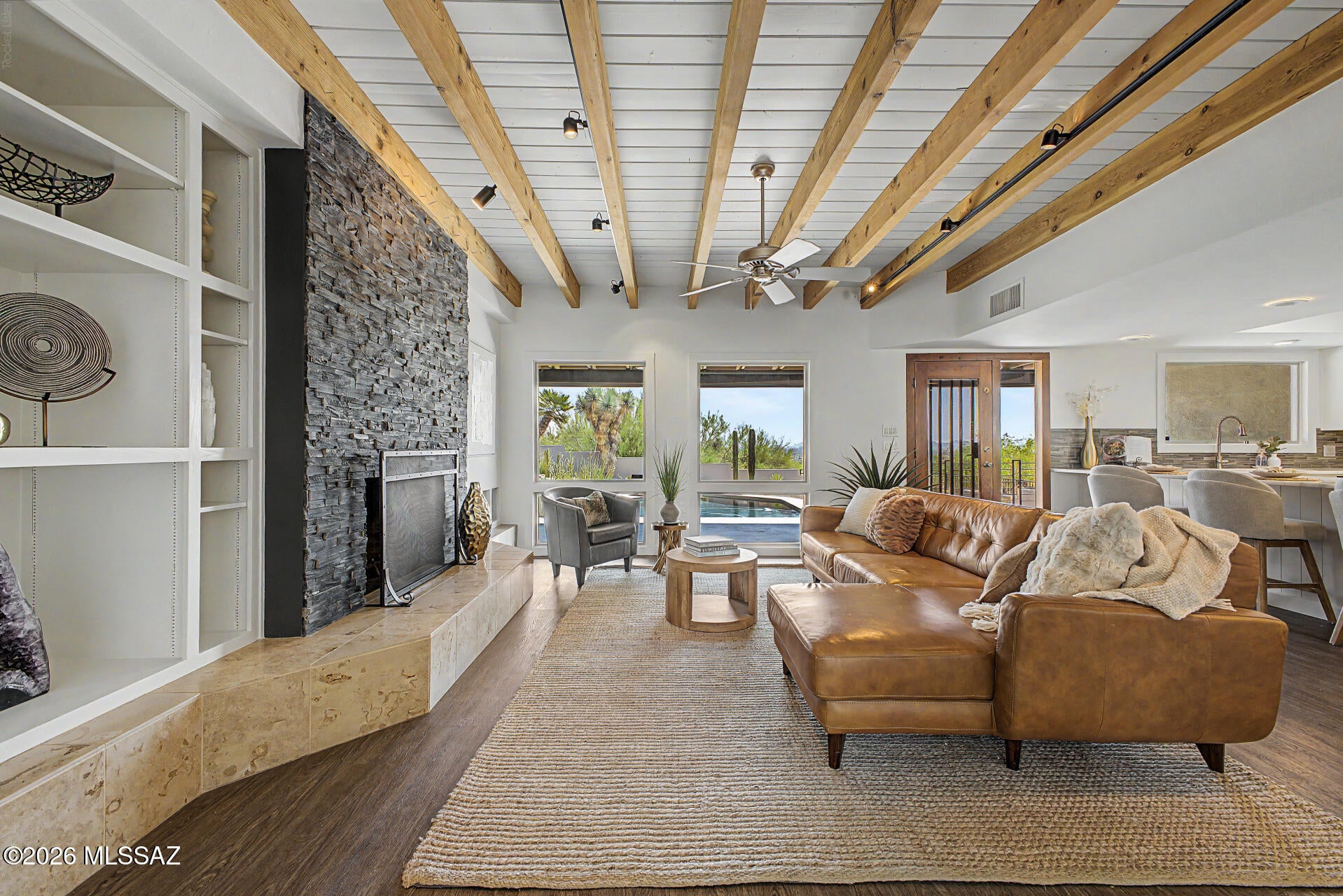 Proudly presenting this exceptional 4-bedroom estate on a premium 1-acre lot, where modern elegance meets timeless design. From the moment you step inside, you'll be captivated by soaring ceilings, abundant natural light, plantation shutters, wood-look flooring, and designer finishes throughout. The stunning open-concept great room showcases exposed ceiling beams and a cozy fireplace, creating the perfect space for entertaining and everyday living. The gourmet kitchen is a chef's dream, featuring stainless steel appliances, mosaic tile backsplash, recessed and under cabinet floor lighting, a skylight, and a peninsula with breakfast bar. Plus, enjoy the versatility of a dedicated den or home office. Owner's retreat offers direct outdoor access, an ensuite with a make-up desk, an enclosed glass shower, and a walk-in closet. Enjoy mountain silhouettes from your wonderful backyard oasis, highlighted by a covered patio, fire pit, and a sparkling pool. This gem is the one you've ever dreamed of!