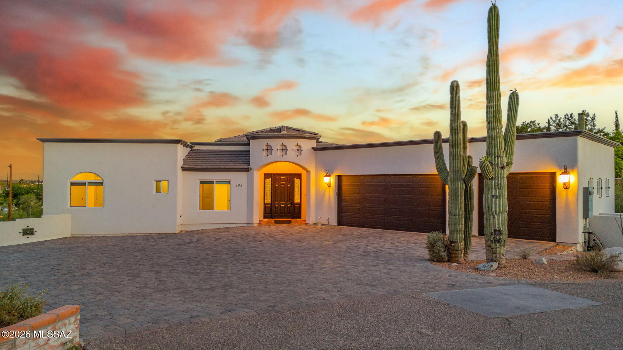 This stunning Santa Barbara style property sits on over an acre of lush desert, featuring soaring saguaros & unbeatable city views. This lightly lived in home features 3 bedrooms, 2-1/2 baths, and a 3 car garage on the main level; while the lower level holds a 1,010 sq ft guest suite complete with its own full kitchen, laundry hookups, Jack & Jill bathroom, living room, and private driveway with separate entrances; giving you the option to turn this into an income producing property. NO HOA. Every detail has been meticulously chosen from the double ovens in the kitchen, to the jetted soaking tub next to the glassless shower in the primary suite. This ideal location places you within 10 minutes of both La Encantada and Tucson Malls, plus is within 30 min of the airport. This is a must-see!