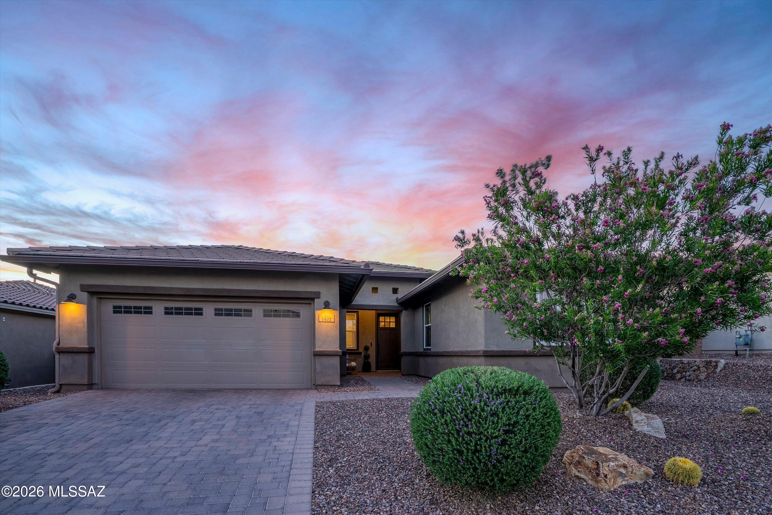 Sophisticated style and understated refinement welcome you to this exceptional residence in the highly sought-after Blue Agave community of world-renowned Dove Mountain's master-planned community. Better than new and meticulously maintained, this stunning 2,519sq ft Ridgeview plan offers 4 bedrooms, 2.5 baths, and a versatile den/office/media room, plus a tandem 3-car garage- all thoughtfully designed to blend comfort, functionality, and elevated finishes.
From the moment you arrive, you'll appreciate your new home's inviting presence and beautifully upgraded front elevation. Positioned on premium Lot 133, which carried a builder lot premium,  your home is complemented by an upgraded paver driveway and entry walkway that add charm and character from the street. Come inside to discover a pristine, bright and welcoming interior finished in a carefully selected neutral designer palette that complements virtually any décor style. Upgraded 8-foot interior doors throughout the home create a sense of volume and custom craftsmanship, while abundant natural light enhances the home's open and inviting atmosphere. Updated lighting fixtures and ceiling fans add contemporary character throughout.
The flexible floor plan has been thoughtfully designed to accommodate a variety of lifestyles. Just off the main living area, the spacious den offers endless possibilities as a home office, media room, study, playroom, or even a potential fifth bedroom. Elegant double 12-lite French doors with sidelites provide privacy while allowing natural light to flow through the space, creating an ideal balance of openness and separation.
The main living areas showcase upgraded Hill House Natural wood-look porcelain tile in a 6x36 format, installed in a premium stair-step pattern and finished with rich walnut grout. Extending throughout the primary living spaces, hallways, powder room, and bathrooms, the flooring delivers both beauty and durability while contributing to the home's cohesive design aesthetic.
At the heart of your home, the expansive great room and dining area offer a warm and welcoming environment for everyday living and entertaining alike. The generous dining space flows seamlessly into the great room and kitchen, providing flexibility to arrange and utilize the space according to your needs. Custom cabinetry has been thoughtfully added, offering valuable storage while introducing texture, warmth, and architectural interest.
The chef-inspired kitchen is enhanced with an upgraded structural layout designed for both functionality and style. Anchored by a grand center island that naturally becomes the gathering place for family and guests, the kitchen features top-tier appliances, reverse osmosis filtration, abundant cabinetry, a built-in desk area, and a charming breakfast nook for more intimate dining experiences. A sleek backsplash adds a polished finishing touch, while carefully selected designer light fixtures contribute to the kitchen's sophisticated appeal. The premium Kohler Cairn single-bowl undermount sink in Matte Black offers both durability and visual impact, while the Arbor oil-rubbed bronze kitchen faucet complements the home's coordinated design selections.
Throughout the home, upgraded oil-rubbed bronze plumbing fixtures create a consistent and timeless aesthetic. Moen Eva series faucets add a layer of quality and refinement to each space.
Split-bedroom configuration provides excellent privacy for family members and guests alike. Three generously sized secondary bedrooms are situated separately from the primary retreat and feature upgraded Level 3 "Sumptuous Cashmere" carpeting paired with a dense premium 8lb Vessel carpet pad, delivering exceptional comfort.  Hall bath has beautiful floor-to-ceiling tile at the tub and shower, creating a more custom and enduring finish. Dual vanities provide convenience and functionality. 
Your primary suite serves as a peaceful sanctuary, offering abundant natural light, spacious proportions, and even a mountain view that adds to the room's relaxing ambiance. The ensuite bath has been designed to evoke the feeling of a private spa retreat. The highly desirable oversized walk-in shower showcases beautiful tile work, a matching tile floor, and a dedicated spa niche for convenience and elegance. Dual vanities provide ample personal space, while the expansive walk-in closet completes this luxurious owner's retreat.
An expansive laundry room with sink, a chic half bath and a dashing mud room area are just off the commodious 3-car tandem garage. Does not get any better than this. 
Outdoor living is equally impressive. Enjoy Tucson's breathtaking sunsets from a backyard designed for relaxation and connection with the surrounding desert landscape. A custom travertine patio surrounds the inviting fire pit, creating the perfect setting for evening gatherings. Artificial turf offers a comfortable surface for recreation and everyday enjoyment, while the extensive covered patio features a sleek epoxy floor coating for durability and style. A natural gas connection makes outdoor grilling effortless, and the view fence enhances the sense of openness while framing the beauty of the desert beyond.
The home also includes several valuable structural and technology upgrades that contribute to everyday convenience and peace of mind. Whole-house surge protection provides advanced electrical safeguarding for your home and devices. A structurally installed 110-volt floor outlet in the great room.  It even has a water softener and gutters!
Beyond the home itself, residents enjoy the unparalleled lifestyle that has made Dove Mountain one of Southern Arizona's most desirable master-planned communities. Nestled against the dramatic backdrop of the Tortolita Mountains, Dove Mountain offers miles of scenic hiking, biking, and walking trails that showcase the Sonoran Desert's remarkable beauty. Residents enjoy access to world-class golf, including courses associated with the renowned Ritz-Carlton Dove Mountain, as well as luxury resort amenities, fine dining, wellness experiences, and year-round recreation.
The community is known for its stunning natural surroundings, dark-sky views, abundant wildlife, and spectacular sunsets. Parks, open space, and thoughtfully planned neighborhoods create an atmosphere that feels both private and connected. Convenient access to shopping, dining, healthcare, and major transportation routes further enhances everyday living while preserving the tranquility that makes Dove Mountain so special. Families benefit from access to Dove Mountain CSTEM K-8 School, a highly sought-after Marana Unified School District campus with a 7/10 GreatSchools rating and a unique focus on computer science, technology, engineering, and mathematics in an innovative, hands-on learning environment.
Combining thoughtful upgrades, flexible living spaces, premium finishes, and an exceptional location, this remarkable Blue Agave residence presents a rare opportunity to enjoy refined desert living in one of Marana's most coveted gated communities.