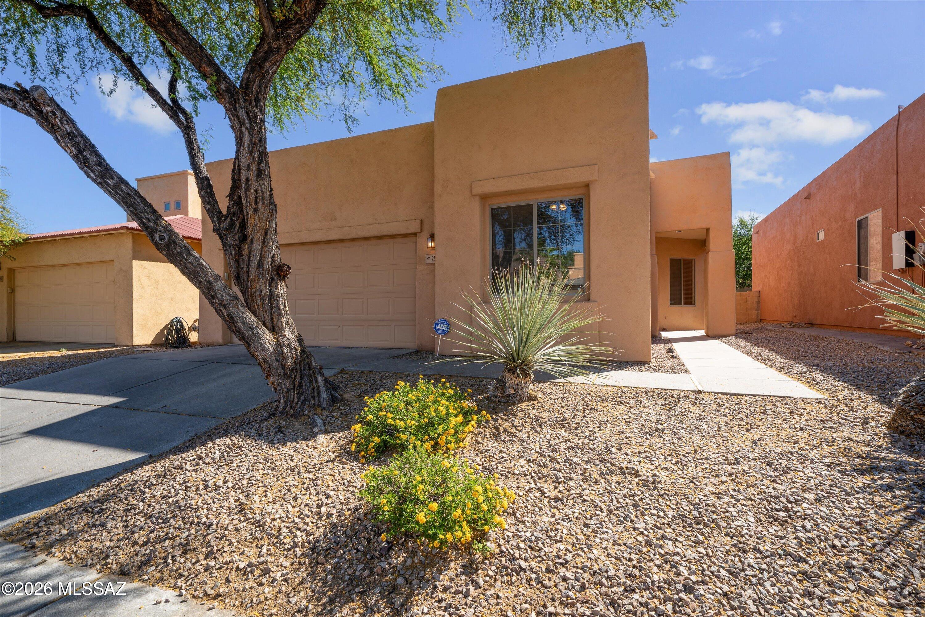 Just move in and relax! This stunning 3-bedroom, 2-bathroom Santa Fe-style home is tucked away in a quiet, gated community in the established Northeast neighborhood. Spanning 1,854 sq. ft., the home features a freshly painted interior and brand-new carpet throughout. The open-concept living area, complete with a cozy fireplace and built-in entertainment center, flows seamlessly into a spacious kitchen boasting a center island and recessed lighting. Retreat to the primary suite featuring dual sinks and a separate shower and soaking tub. Enjoy the private back yard with a covered patio and the peace of a secluded neighborhood with Udall Park, shopping, and dining just minutes away