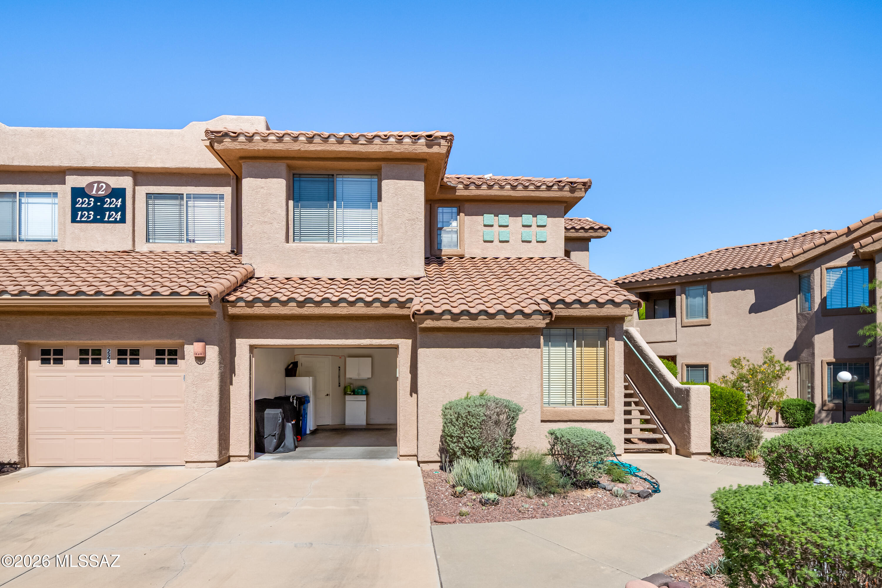 Resort living at its finest! This stunning - ground floor - 2BD/2BA condo features an open floor plan with luxury vinyl plank flooring and a single car garage with storage room. The remodeled, chef's kitchen impresses with granite countertops, tile backsplash, stainless appliances, and a built-in coffee bar. Enjoy the spacious living and dining areas, perfect for entertaining. The primary suite offers a serene retreat with a wall-mounted TV and en-suite bath boasting dual granite, executive height, vanities. A dedicated entertainment niche, covered patio, and generously sized second bedroom complete this exceptional home. Heated community pool/spa, fitness room, water, trash, internet, BBQ areas, and exterior maintenance/pest control included with HOA dues. Don't miss this gem!