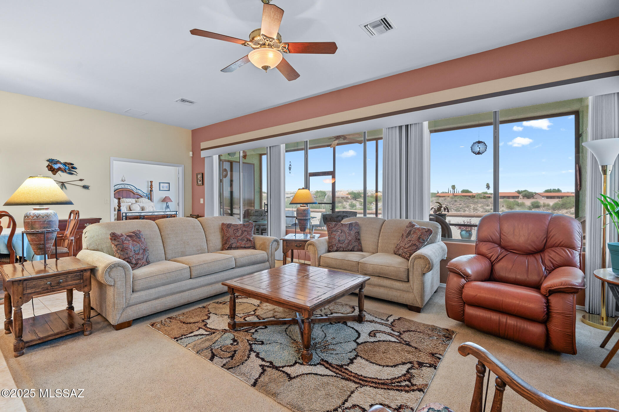 Experience the epitome of the serene Arizona lifestyle in this immaculate single-family residence, nestled in a prestigious gated community--a haven for retirees seeking tranquility and comfort. The original owner's loving attention is evident in every corner of this carefully maintained abode.  Step inside to discover the expansive great room, boasting a 10-foot ceiling and large windows that frame the breathtaking desert panorama, inviting the natural splendor inside. The spacious kitchen is a culinary delight, featuring a generous center island, sleek black stainless steel appliances, and stylish pendant lighting. A charming breakfast nook, thoughtfully expanded, offers the perfect spot to enjoy your morning coffee or lighter fare meals.  Double French doors lead to a versatile office