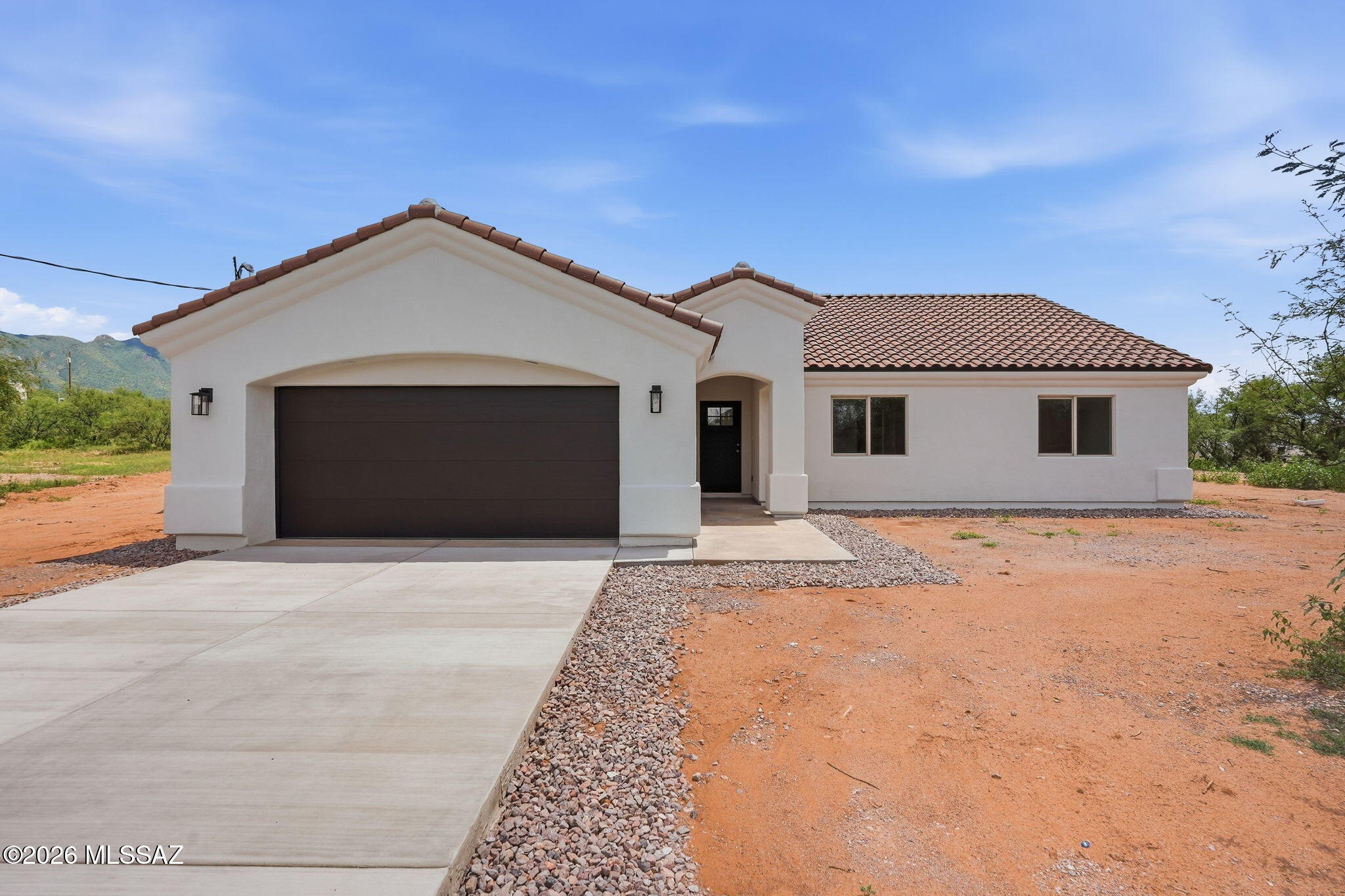 Grand Desert Homes of Rio Rico presents this beautifully finished property offering clean, modern style, spacious interiors, and incredible mountain views. The kitchen is a standout, featuring rich custom Alder wood cabinetry handcrafted in Hermosillo, Mexico. Built with quality materials and craftsmanship, these cabinets are designed for lasting durability and offer a level of character and construction beyond standard big-box cabinetry. Ideally located near the entrance of Avenida Pastor, the property offers convenient access to the freeway, making commuting and everyday travel quick and easy while still enjoying the peaceful surroundings and beautiful desert scenery. This new construction home includes warranty coverage on its structural components and features a premium TRANE HVAC unit