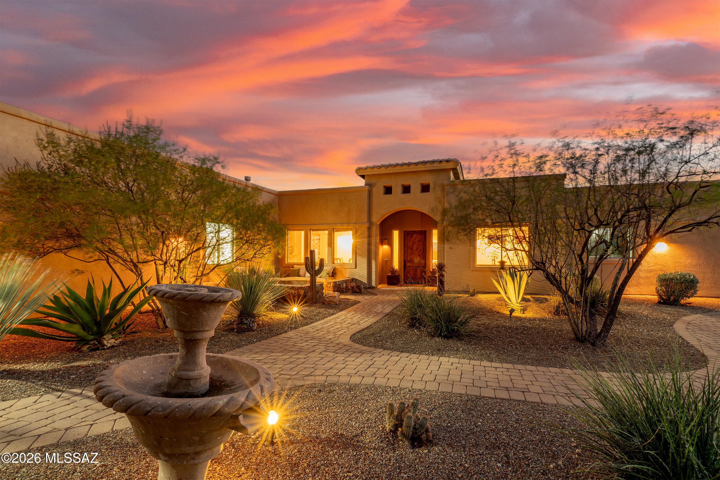 Experience elevated desert living in this beautifully appointed custom home, ideally situated on 2.2 scenic acres within the prestigious gated community of Coyote Creek. Spanning nearly 3,800 square feet, this thoughtfully designed residence showcases sweeping views of the Rincon and Catalina Mountains while backing to a wide natural wash and open desert, creating an exceptional sense of privacy and tranquility.
A paver driveway leads through a welcoming stone courtyard with a tranquil fountain before revealing an interior designed for both everyday comfort and effortless entertaining. The home offers multiple living areas, three bedrooms, four bathrooms, a private den, and a versatile bonus room adjoining the spacious primary suite, ideal as a home office, fitness room, sitting room, or secluded retreat.

At the heart of the home, the gourmet kitchen features granite countertops, a slate backsplash, and generous workspace for cooking, gathering, and entertaining. Car enthusiasts and hobbyists will appreciate the remarkable 1,640-square-foot, eight-car garage, with one bay currently configured as a fully functional indoor batting cage.

The resort-inspired backyard is designed for year-round enjoyment, featuring a custom pool with dual water features, spa, putting green, artificial turf, expansive paver patios, custom fencing and gates, decorative stonework, striking Desert Steel art installations, and retractable sunshades.

Recent updates enhance both style and function, including fresh interior and exterior paint, remodeled fireplace surrounds with reclaimed wood mantels, and new window coverings. (See Upgrade Document for a complete list.) Major system improvements include two newer HVAC systems and two newer water heaters, offering lasting comfort and efficiency.

Life in Coyote Creek offers a rare connection to the Sonoran Desert with an unmatched sense of space and serenity. Residents enjoy state-of-the-art equestrian facilities, pickleball, tennis and basketball courts, scenic riding and walking trails, and access to the highly regarded Vail School District.

If you're seeking luxury, privacy, and exceptional amenities in one of Southern Arizona's premier gated communities, this extraordinary home offers an unparalleled desert lifestyle.