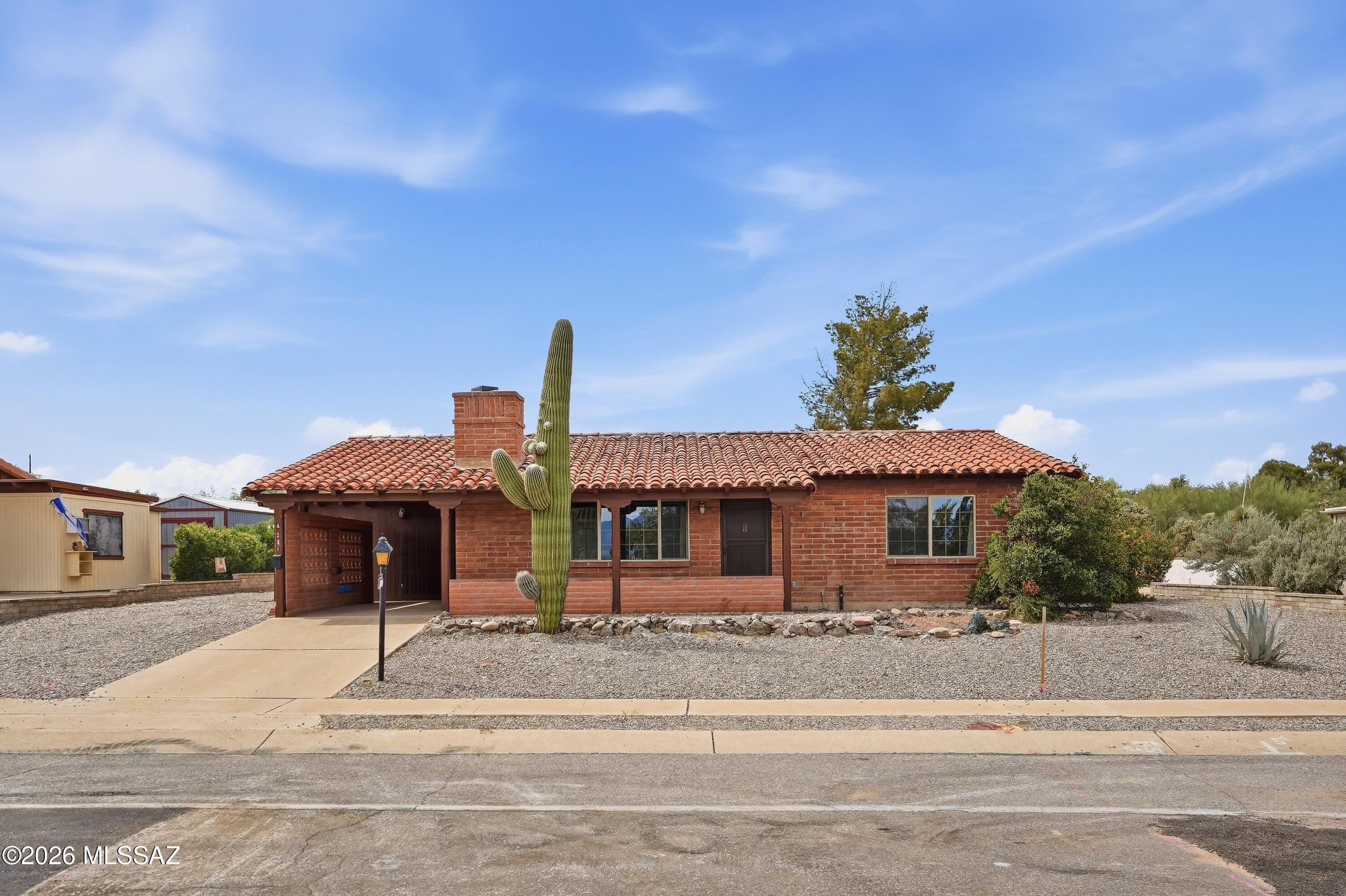 Charming 2-bedroom, 2-bath home featuring desirable slump block construction and a spacious Arizona room for additional living or entertaining space. The kitchen offers granite countertops, travertine backsplash, and stainless steel appliances. Both the primary and guest baths have been tastefully updated. Additional improvements include newer windows for added comfort and efficiency. Situated on a large ¼-acre lot with plenty of outdoor space to relax, garden, or entertain. An attached one-car carport adds convenience. A wonderful combination of solid construction, thoughtful updates, generous lot size, and classic Arizona living! Flat roof recoated 2026.