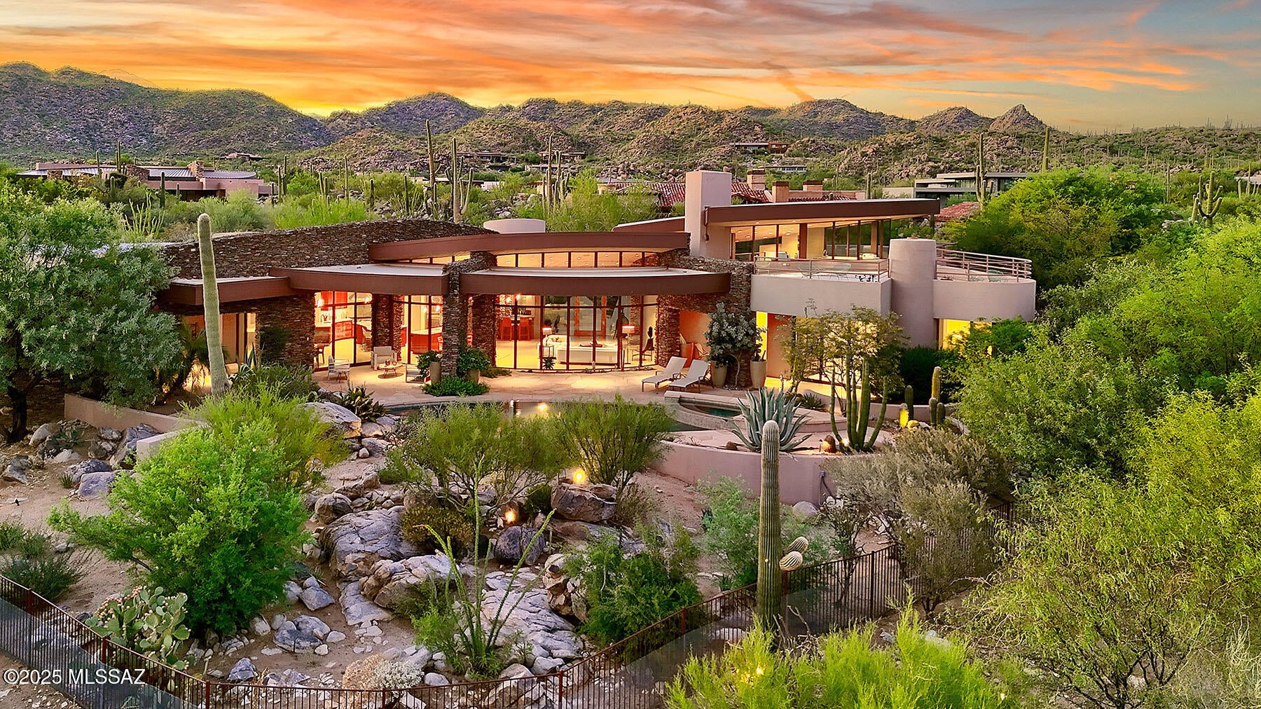 Designed by acclaimed Tucson architect Kevin Howard, this dramatic contemporary residence offers exceptional privacy, timeless elegance, and breathtaking views of the Catalina Mountains and Pusch Ridge--all set across the 11th fairway of the world-class Stone Canyon Golf Course. An etched glass entry leads into a striking living room with floor-to-ceiling windows, limestone flooring, and rich natural light. Every detail has been thoughtfully planned, including 8-foot solid wood doors with metal inlays, designer lighting fixtures, and warm stone accents that create an inviting, yet sophisticated modern aesthetic.  The main house (4,343 sq. ft.) features expansive living room with metal-clad fireplace, wet bar with wine refrigerator, chef's kitchen with premium appliances and finishes,
