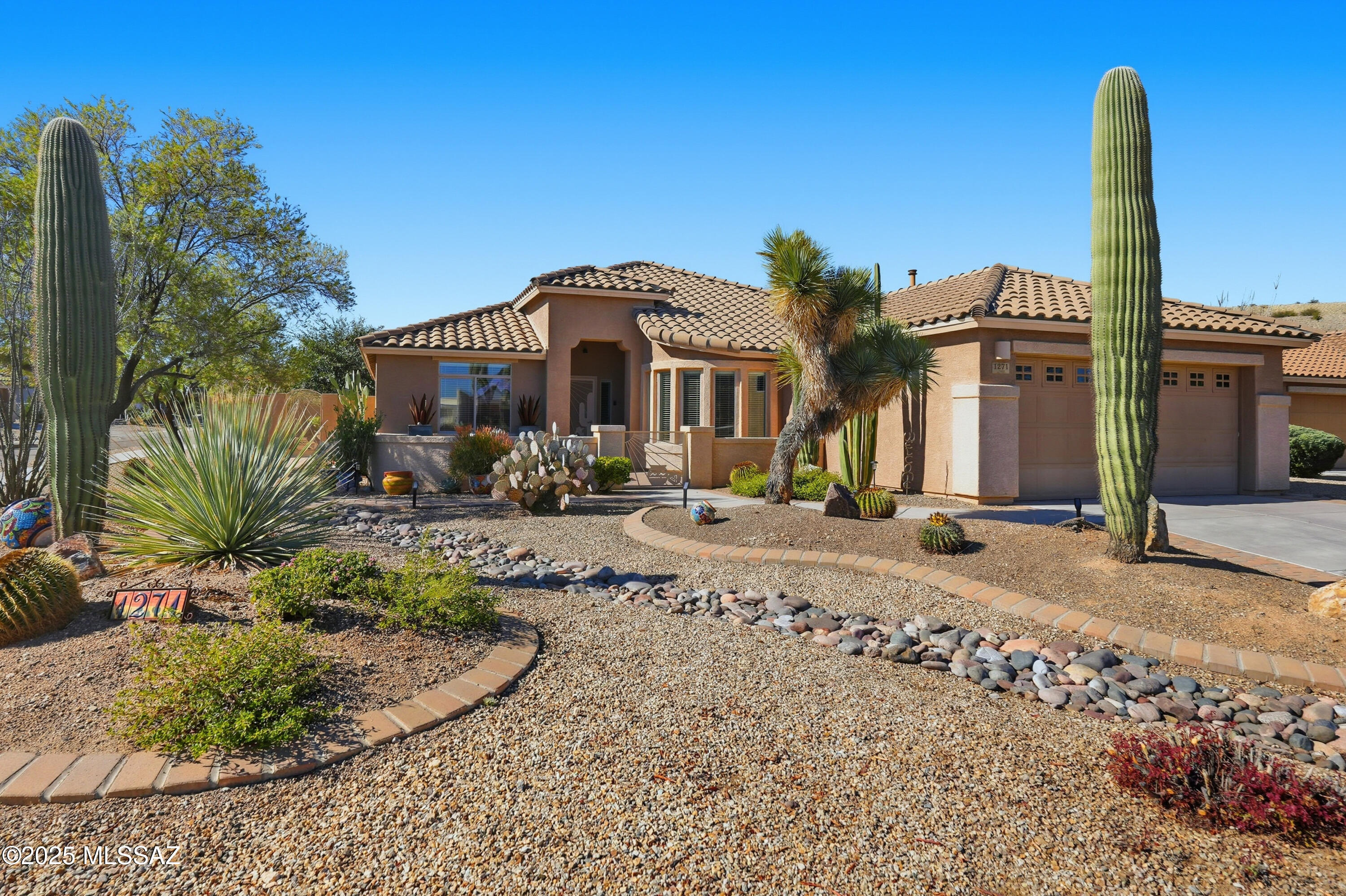 Experience the joy and ease of Southwest living at 1271 N Via Alamos, a gorgeous and stylish home in the heart of Green Valley. You're welcomed by a thoughtfully designed front courtyard with beautiful mountain views, creating an inviting first impression.

Inside this 1,766-square-foot home, the bright and open floor plan features tile flooring and tasteful paint tones throughout. The spacious modern kitchen includes a breakfast bar, granite countertops, stainless-steel appliances, abundant storage, and generous counter space. It flows seamlessly into the dining area, making it perfect for everyday living and effortless entertaining. The split floor plan enhances privacy. The large primary suite offers room for a sitting area, a generous walk-in closet, and an upgraded bath with granite surfaces and contemporary finishes. A well-sized guest bedroom provides comfort for seasonal visitors, while a versatile bonus room with built-ins is ideal for a library, office, or hobbies. A laundry room with additional storage and counter space adds convenience to the home's thoughtful layout.

Step outside to an expansive paver patio featuring a pergola, remote-controlled sunshades, multiple seating areas, and a paver walkway leading to a raised patio. This spacious backyard is designed for year-round desert enjoymentquiet, private, and naturally connected to the surrounding landscape.

Conveniently located near GVR recreation centers, golf courses, hiking trails, and shopping, this home offers the best of Green Valley living.

A rare combination of space, views, and thoughtful designcome see it today.
