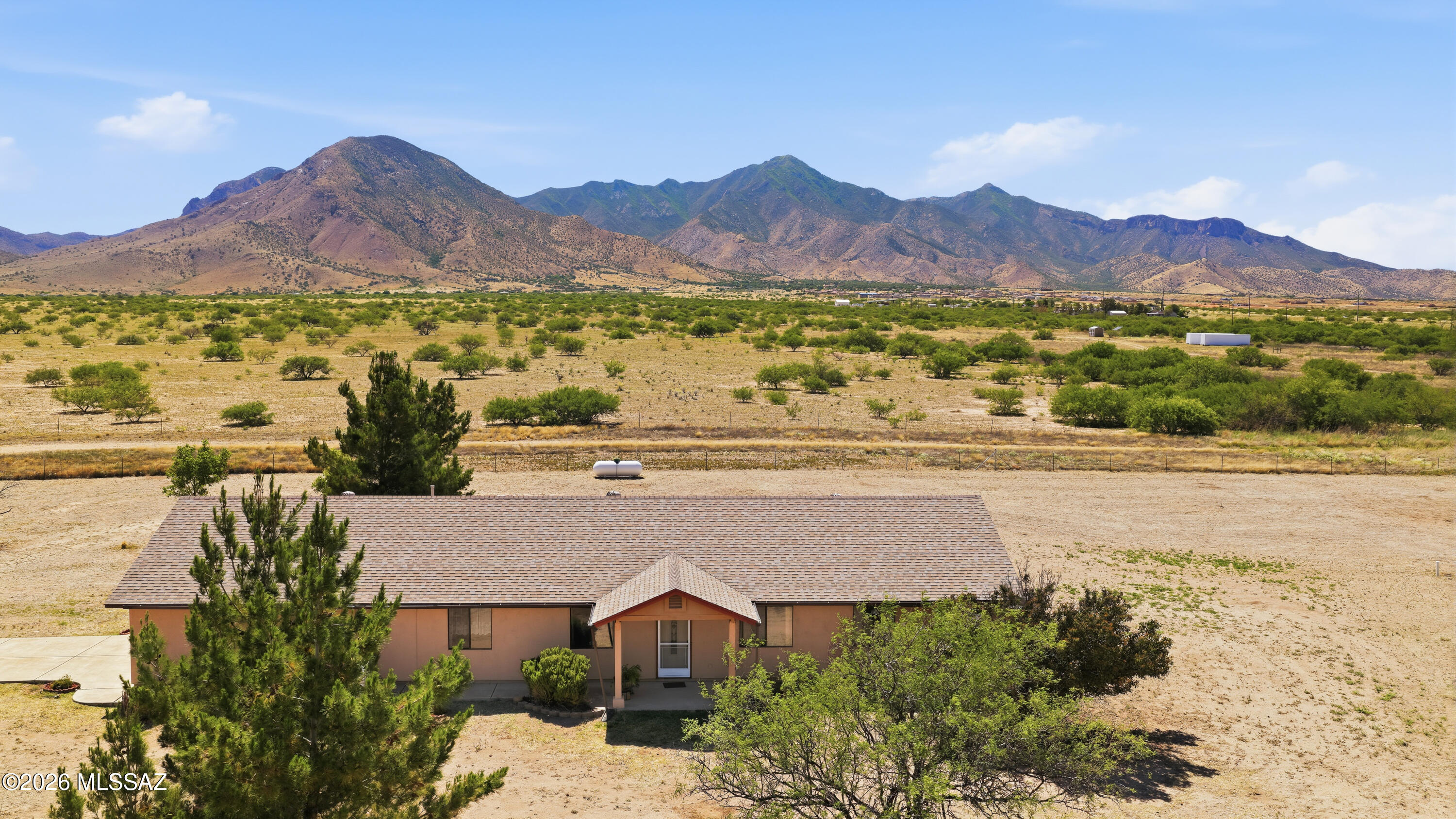 Beautiful 3-bedroom home featuring a split floor plan, tile flooring with carpet in the bedrooms, and a spacious kitchen complete with a walk-in pantry, gas range, refrigerator, and dishwasher. Large windows throughout the oversized living room fill the home with natural light while showcasing stunning unobstructed mountain views and breathtaking Arizona sunrises and sunsets. Situated on 4.5 acres on a corner lot, this property offers peaceful country living with plenty of space for horses, additional structures, RV parking, or outdoor hobbies. Home features a new roof, attached painted 2-car garage, plus a detached shed/1.5-car garage for extra storage and workspace.