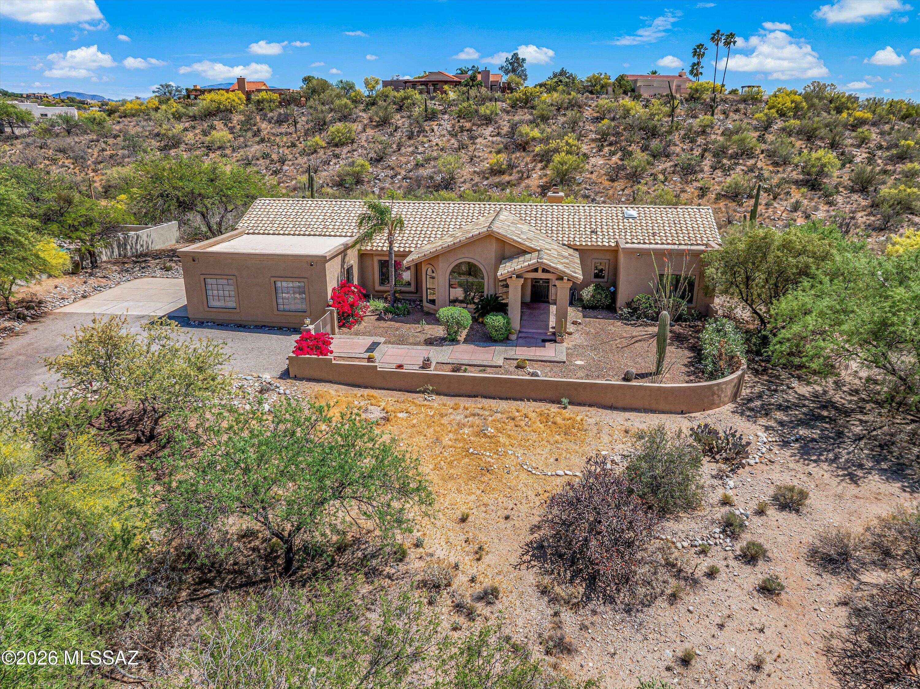 50k PRICE REDUCTION! If you are looking for a Foothills home, this one is a must see! Located near the base of the Catalina Mountains and in the prestigious Catalina Foothills School District. Hard to find 4 bedrooms and 3 full baths with a split bedroom plan and oversized 3-car garage. Private .85 acre lot with big mountain views from the front of the home (courtyard, living and dining rooms, and Bedroom #2). The fully fenced backyard has an extended covered patio, Ramada, and built-in grill. Lots of space to add a play area and pool and make this a dream yard! The family room off the kitchen has a fireplace, full size laundry room/pantry and openings to the formal living and dining room. New interior paint throughout the entire home and garage. This one-owner home is a Foothills gem.