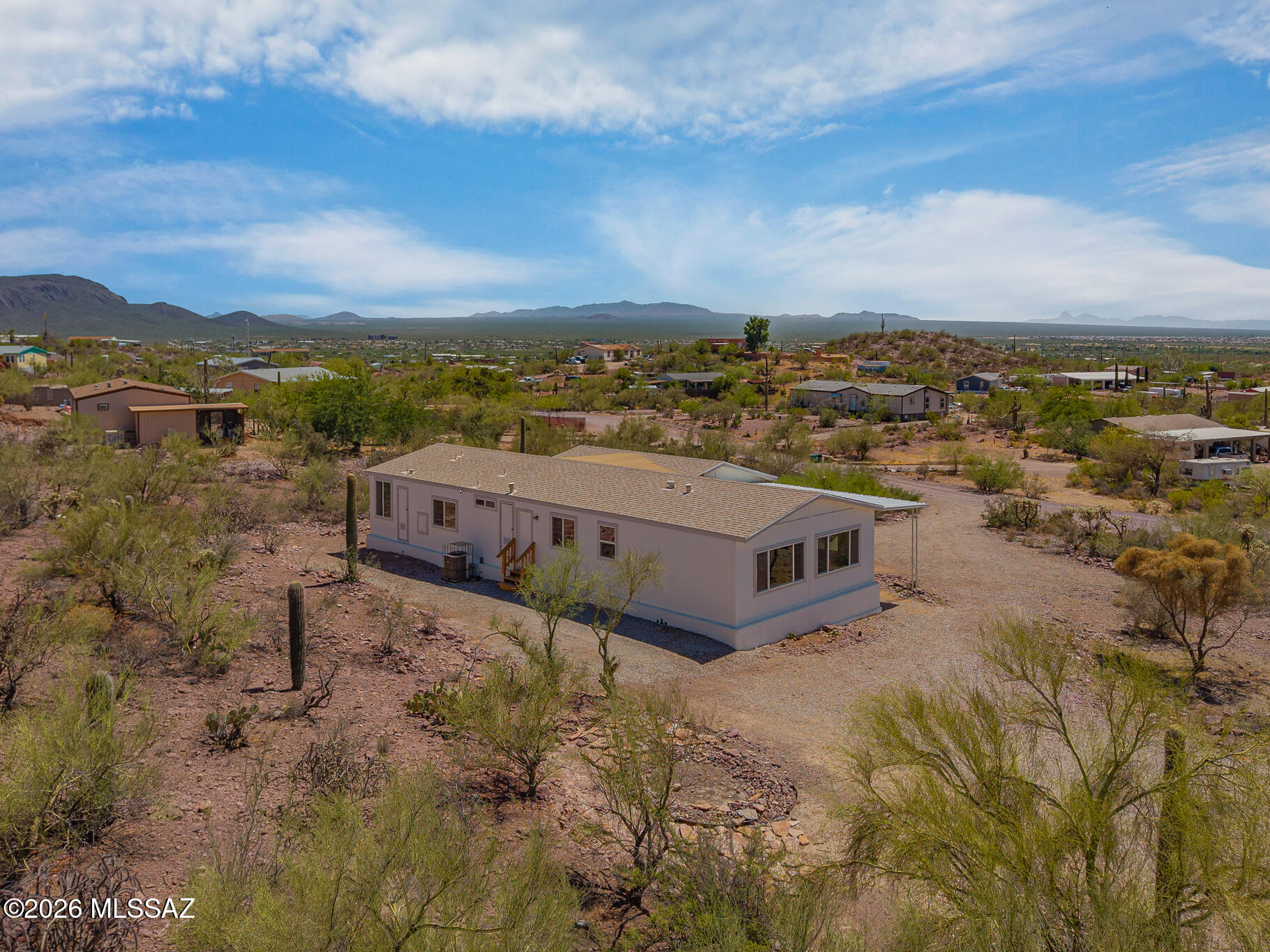 Welcome to this beautifully remodeled 4-bedroom, 2-bathroom manufactured home situated on a full acre of horse-zoned land, offering the perfect blend of modern comfort and peaceful desert living. Inside, you'll find a bright open floor plan with new flooring, fresh paint, updated lighting, and a stylish kitchen featuring white shaker cabinets, stainless steel appliances, and generous counter space. The spacious primary suite features a beautifully renovated ensuite with dual vanities, a soaking tub, and separate shower. Outside, the expansive acre provides endless possibilities for horses, RVs, trailers, a workshop, or future improvements. Enjoy breathtaking mountain views, stunning Arizona sunsets, and the privacy of country living while remaining just a short drive from city conveniences.