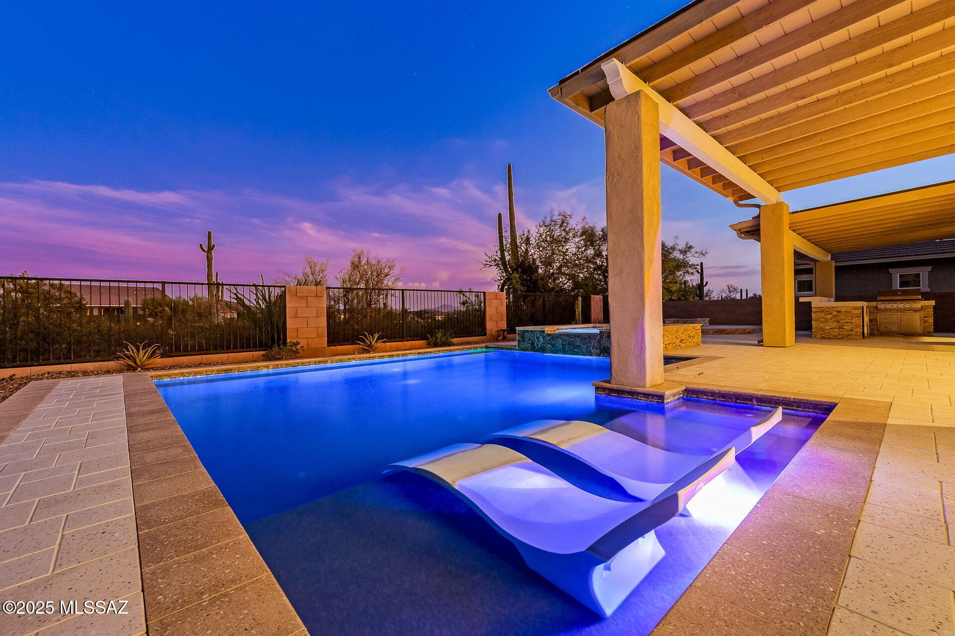 Resort-like living awaits at this Dove Mountain property, nestled within the gated community of Golden Barrell Place. The backyard is an entertainer's dream, offering a seamless indoor-outdoor lifestyle. A 12-foot roof extension on the back patio provides constant shade in every season. With a custom heated pool and spa, built-in BBQ, a dedicated prep area, and a gas fire pit, this backyard is perfectly set up for a full-time resident or seasonal visitor.

Completed in 2017 this versatile single story with a 3-car garage, 2,904 square feet, 4 bedrooms, a den, and 3 bathrooms allows for a variety of uses. This home lays out beautifully with a split-floorplan creating privacy and functionality in each of the spaces. Interior features include a spa-like primary bathroom shower, ceramic tile throughout all public spaces, fully enclosed den or office, staggered kitchen cabinetry, large walk-in pantry, prep area or coffee bar space and soaring 12 ft ceilings in the great room capturing natural light and desert views.  Outside you will find its custom patio roof extension that provides shade over a portion of the pool and outdoor kitchen.  The limestone pavers create continuity throughout the outdoor spaces for a clean and finished look.  Step up to the built in gas fire pit to enjoy the views of the Tortolita Mountains and watch the sky change colors at sunset.
 
Within Dove Mountain, residents may enjoy the Wild Burro public access trail head just through the gates of the Ritz-Carlton Dove Mountain, The Gallery Golf & Sports club, golf and dining at The Highlands, the Tortolita Preserve for trail running and mountain biking, generous cycling lanes on the road, an off-road walking path spanning the length of Dove Mountain Blvd, and 2 beautiful parks. The recently constructed Dove Mountain C-Stem K-8 school provides bus service, or an easy drop off for those commuting.