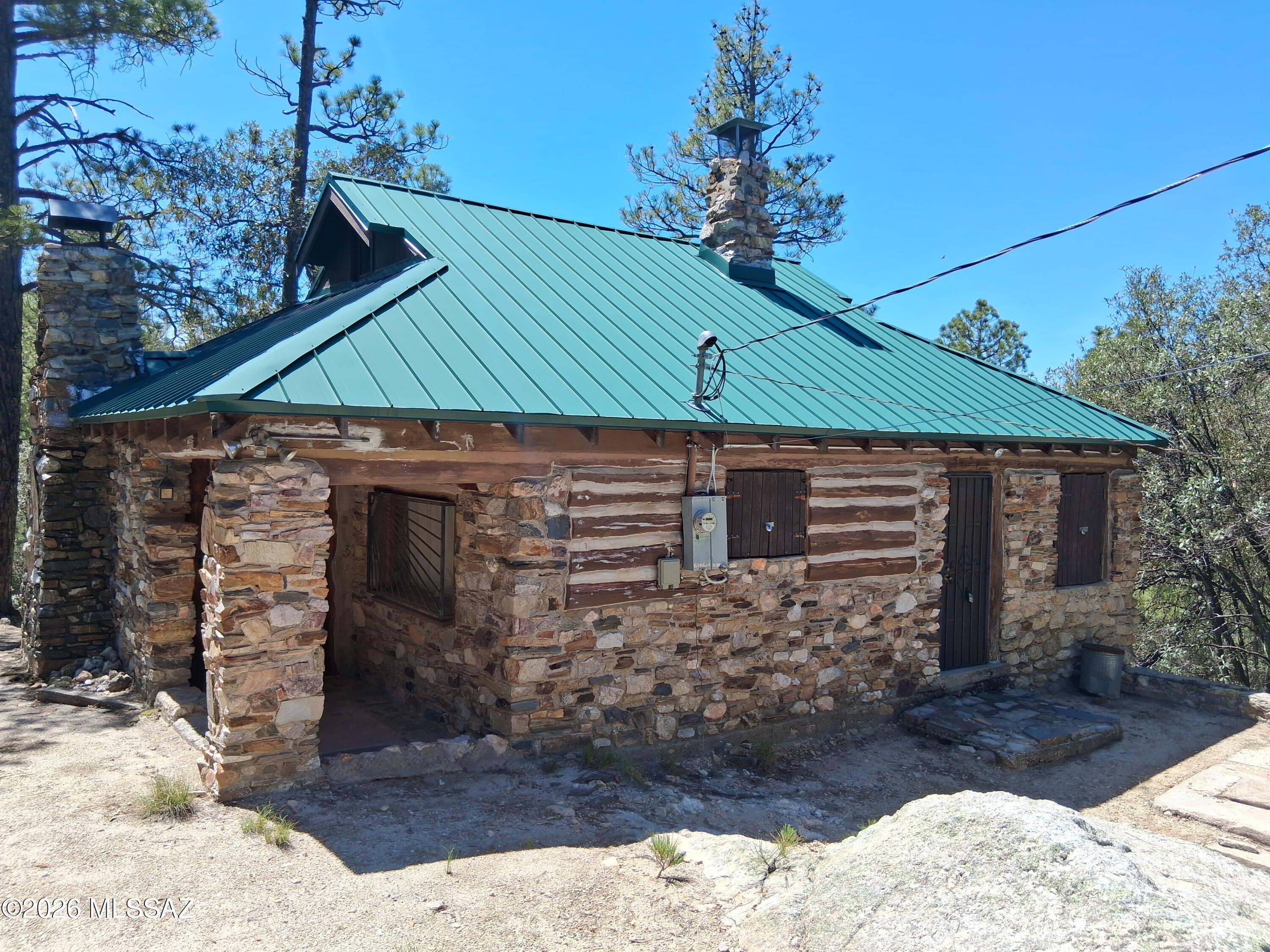 This 1947 Gorgeous rock cabin is one of a kind on Mt Lemmon..  Flat to the door access! The large heart shaped rock on the fireplace says it all.  This 1 bedroom plus a loft on US Forest Service lease land views Lizard  Rock. Surrounded by large trees on the North  Willow Canyon Loop provides privacy.  Remodel has been started-needs completion.  Perfect for the person who wants to add their own personal touches.  Must see to fall  in love with this old world grace and charm.   Huge log beams cross ceiling, all wood ceiling inside with metal roof added in 2003. Tall wood burning fireplace and wood burning stove.  Solid rock  entry leads to cement floor. Original 1940;s cabinets and large wooden table add to that historic charm.  Current USFS Special Use Permit  is approximately $3200.00/yr