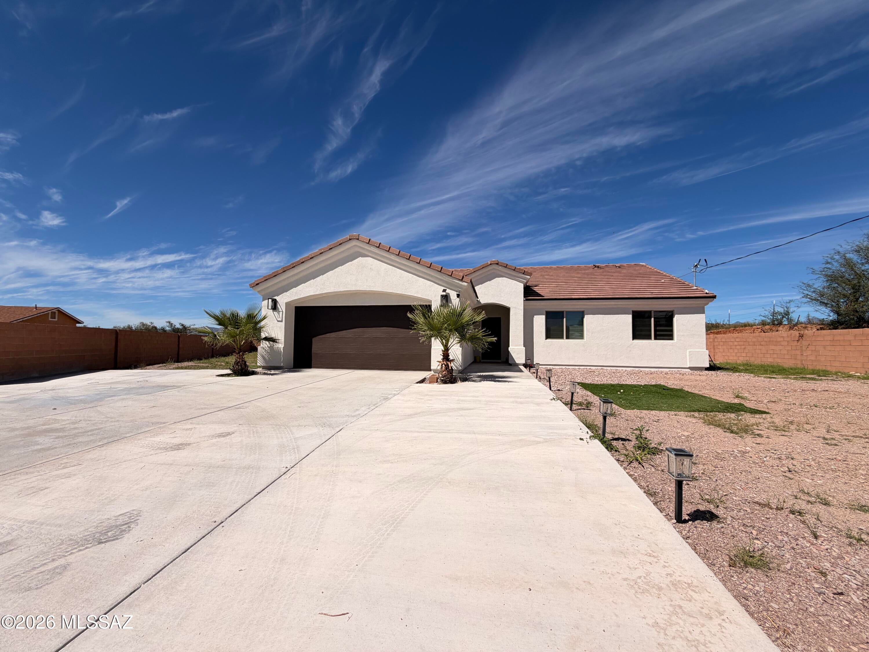 Welcome to 64 Cabana Ct! This beautiful 3-bedroom, 2-bath home offers lots of space and spacious living space on large 0.59 acre lot in Rio Rico. Built in 2024, the home features an open-concept layout, high ceilings, granite countertops, ceramic tile flooring, and a split-bedroom floor plan. Recent improvements include a block wall and extended concrete driveway, adding privacy and functionality. Enjoy a covered patio, generous outdoor space, surrounding views, and a 2-car garage. Tucked away on a quiet cul-de-sac, this home offers plenty of space inside and out. Schedule your showing today!