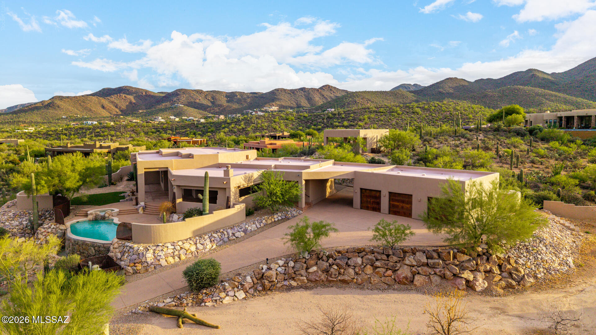 Ascend the stately aggregate drive to an extraordinary modern contemporary architectural masterpiece, gracefully perched atop a private three-acre, saguaro-studded hilltop with commanding panoramic views of the city skyline and surrounding mountain ranges. Masterfully designed and meticulously constructed with eco-friendly Structural Insulated Panels (SIPs), this exceptional residence embodies the perfect balance of cutting-edge sustainability, timeless sophistication, and uncompromising craftsmanship. A dramatic open-concept floor plan unfolds beneath soaring ceilings and expansive walls of glass that frame spectacular desert vistas while flooding the interiors with natural light. Gorgeous tile floors, designer fireplaces, bespoke custom cabinetry, chiseled granite countertops, and a curated collection of premium stainless-steel appliances create an atmosphere of refined elegance. Designed to blur the distinction between indoor and outdoor living, resort-inspired covered terrace featuring a fully appointed outdoor kitchen, multiple lounge and dining spaces, and a breathtaking negative-edge pool and spa that appear to spill seamlessly into the desert horizon. Every sunset becomes a private masterpiece, creating an unforgettable backdrop for both grand-scale entertaining and intimate evenings under the Arizona sky. Offering unparalleled privacy and tranquility without sacrificing convenience, this remarkable estate is located just six miles--approximately ten minutes--from the vibrant dining, arts, and cultural attractions of downtown, delivering an extraordinary lifestyle where world-class contemporary architecture meets the beauty of the Sonoran Desert.