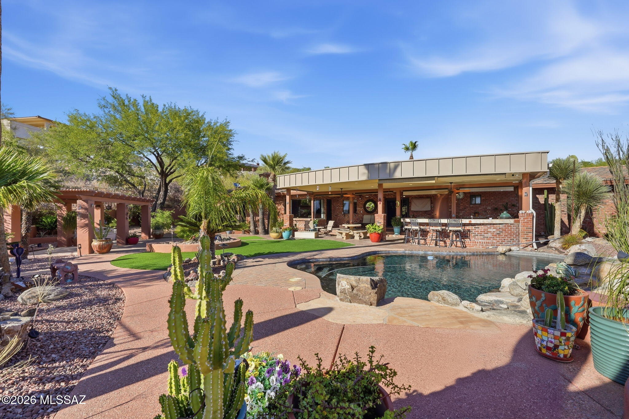 A truly remarkable custom brick territorial w/superior construction & finishes throughout! Enjoy this gracious, traditional single level floor plan updated to suit today's modern lifestyle. Expansive kitchen w/high-end appliances, granite tops & cherry wood cabinets opens to an inviting family room overlooking a resort style backyard.  Big views!  Elegant pool w/water feature, kiva fireplace, outdoor kitchen & extended covered brick patio, create a fabulous entertaining venue. Pergola allows for even more relaxation space. Gas fireplaces in primary suite, family & living rooms. 3 car garage w/lots of storage, 1/2 bath, direct access to backyard.  Concrete tile roof, travertine floors, solid wood doors. Near shopping, Loop, etc. Range priced - seller will respond to offers $900,000-$930,000