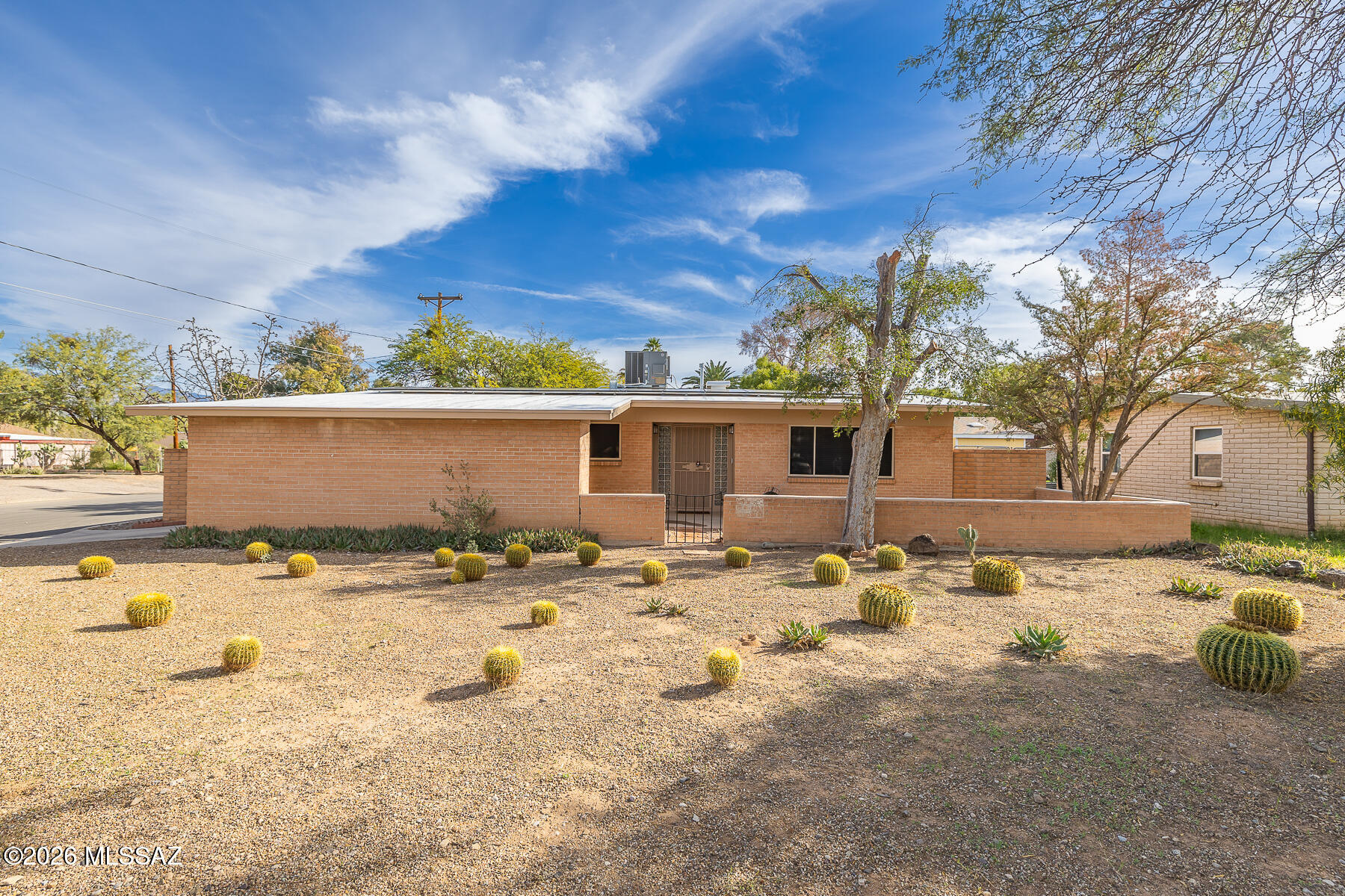 Charming brick rancher centrally located close to U of A schools, Banner Hospital and shopping.  Step inside into a freshly painted interior.  Solid surface flooring is found throughout.  In addition to the living/dining room combo is an inviting family room with a charming corner fireplace.  The kitchen offers a stainless steel  range and dishwasher, micro-wave, and pantry for extra storage plus a cozy breakfast room.  The master bedroom enjoys 2 closets as well as its own bathroom.  The spacious 2nd bedroom has use of a full bathroom steps away.  Outside enjoy the extended patio and large yard enclosed by a brick fence for added privacy and security.  Additional storage in carport area.  Move in ready condition..