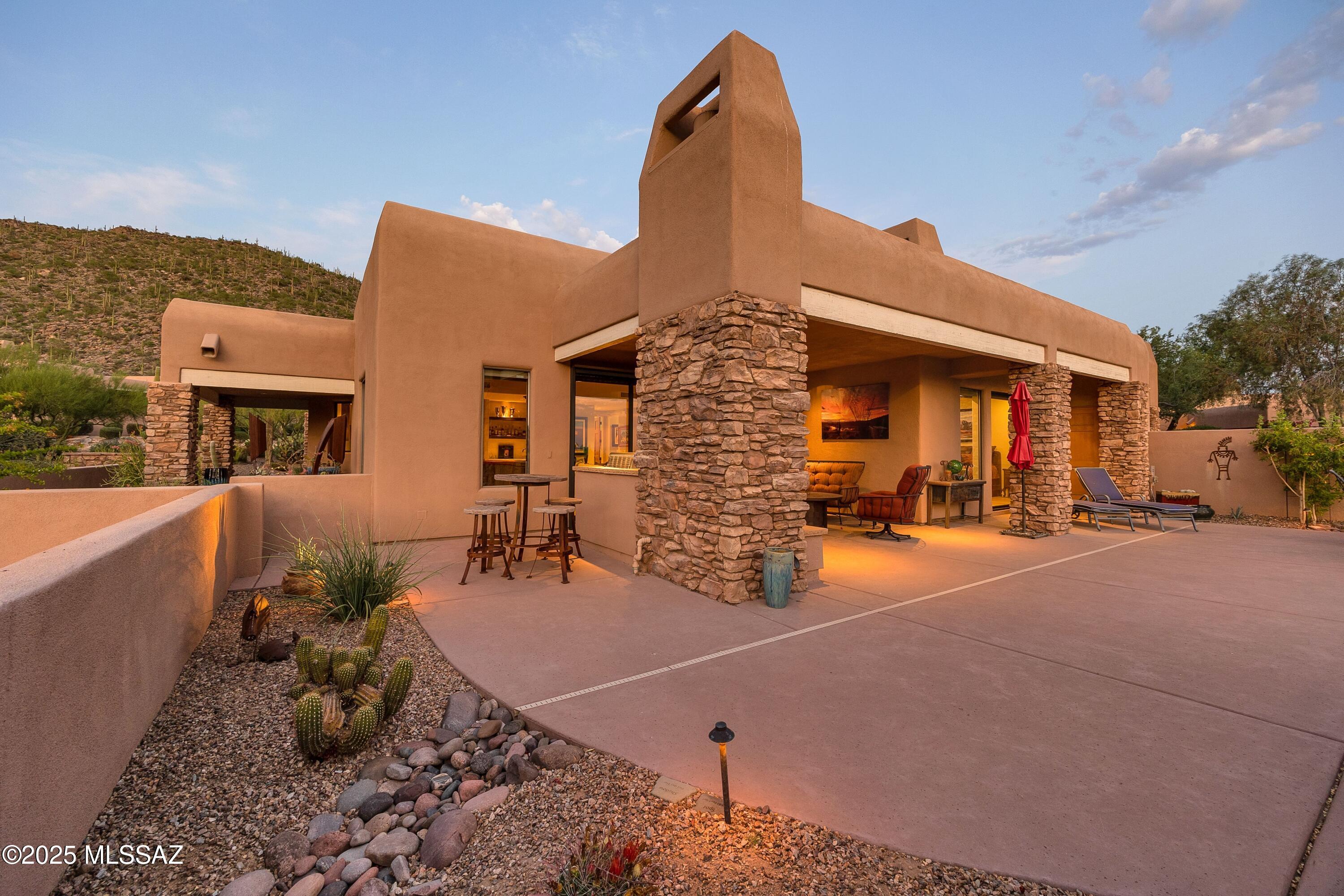 Rarely available and highly sought after, this beautifully remodeled home in the gated Cottages at Dove Mountain offers a refined blend of luxury, comfort, and location. These residences seldom come to market — and even more rare is one that has been remodeled to this caliber. Inside, you'll find a chef's kitchen outfitted with SubZero and Wolfe appliances, custom soft-close cabinetry, granite countertops throughout, and a large island with a custom bar-height counter — ideal for casual dining and entertaining. Warm wood-accented ceilings, new flooring, custom built-ins, and two updated fireplaces elevate the main living spaces, while a wet bar with wine fridge adds sophistication and ease for hosting.  The split bedroom floor plan offers privacy... and flow. The two guest bedrooms are tucked at the front of the home and share a beautifully landscaped courtyard with turf, mountain views, and mature trees  a peaceful outdoor space perfect for morning coffee or quiet evenings. Each bedroom has a walk-in closet and convenient access to a full guest bath.
A telescoping slider connects the main living area to the expansive back patio, where a built-in BBQ, outdoor fireplace, and spa create a true outdoor living experience. Set along the 9th hole known for its water feature, the property enjoys sweeping views of the lake, mountains, and golf course. A Tesla charging system in the garage adds modern convenience to this already exceptional offering.
Located within walking distance of The Gallery Golf Club and just minutes from the Ritz-Carlton Resort and Spa, this home is a rare opportunity to enjoy the best of Dove Mountain beautifully updated, move-in ready, and designed for effortless living.