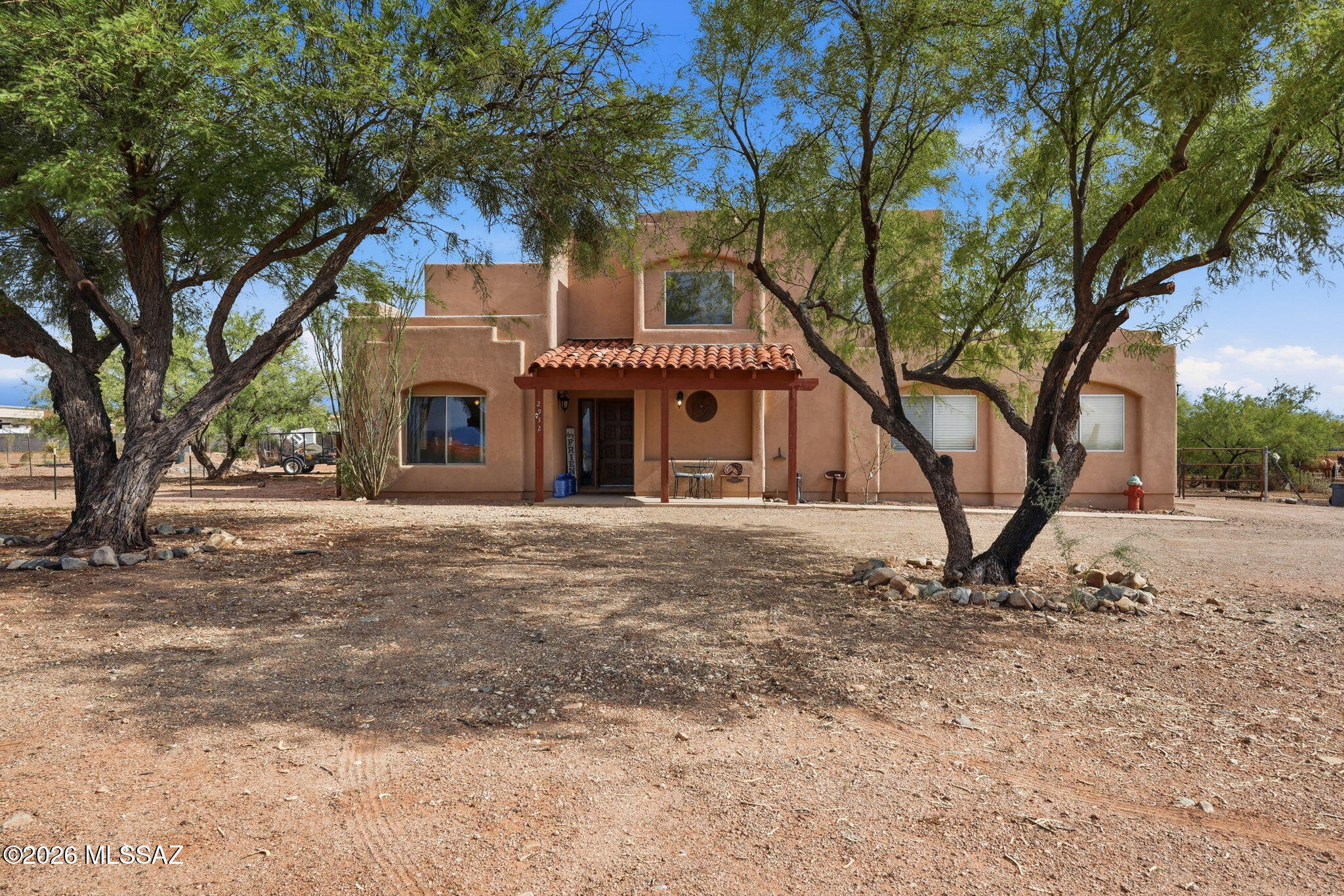 HORSE PROPERTY! Private remote controlled gate leads you into this 2-story Santa Fe style home. Sitting on just over 1acre you have plenty of room for all of your toys! NO HOA!  3 Bedrooms,  2.5 Baths. Saltillo flooring throughout kitchen and living area. Wood burning fireplace located in Livingroom. Covered front porch & extended covered back patio. Horse facilities include 3 covered stalls. Large 2 car garage with room for workshop area. Property located in prestigious Vail School District. Solar powered. Buyer must assume lease.