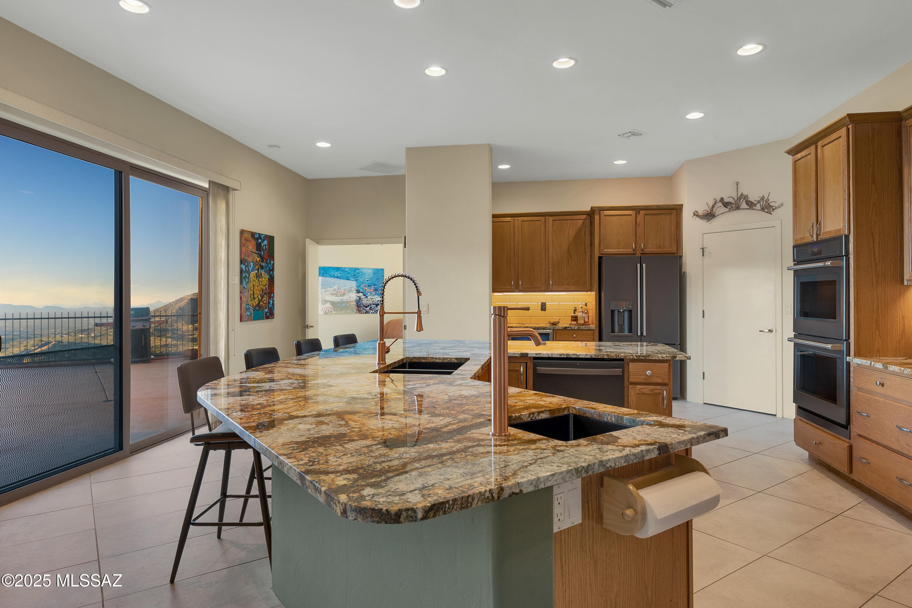 Perched at 4,200' on a spectacular 5-acre promontory in the Santa Rita Mountains, this custom single-story home delivers unmatched privacy, serenity, and sweeping 80-mile panoramic vistas. Located in an exclusive enclave of only 12 homes - each on at least 5 acres - this peaceful community features underground utilities so as not to disturb the views, borders the Coronado National Forest, and offers abundant wildlife, brilliant sunsets, and breathtaking night-sky viewing. Only 35 minutes to downtown Tucson, and just 20 minutes to Rita Ranch shopping, including Walmart, Home Depot, restaurants, and a new Costco and Sprouts planned for 2026-2027. 
Constructed with RASTRA® block for superior thermal and acoustic performance, the home features high ceilings, large-format porcelain tile, multiple skylights, and an open great room with a 14' ceiling, dramatic mountain views, Modern Flames® fireplace, and elegant dining area. The expansive chef's kitchen includes two GE Café French Door refrigerators (2025), GE Café double oven and electric cooktop (2025), dual GE dishwashers (2024), Hauslane® hood (2025), pot filler, built-in wine fridge, and stunning 1" Brazilian granite countertops. A large walk-in pantry completes the space.
Retreat to the spacious primary suite with pool access, walk-in closet, dual vanities, soaking tub, and oversized shower. Two private guest suites each offer en-suite baths and walk-in closets, including one with a 3-season sitting room and patio/pool access. Additional spaces include a dedicated office with built-ins facing the Catalina Mountains, a large laundry room with a brand new LG washer, and a versatile bonus room with barn door and storage.
Outdoor living shines with a 25'x15' solar-heated pool starring extraordinary day and night views. The home is equipped with a silicone-coated roof (2020), two Trane® heat pumps with REME-HALO® purification (2022), dual Bradford-White® water heaters, Sentricon® termite system, updated pool equipment, central vacuum, and a well share with excellent water quality and low annual cost.
A rare combination of luxury, efficiency, and natural beauty - this is Arizona living at its finest.