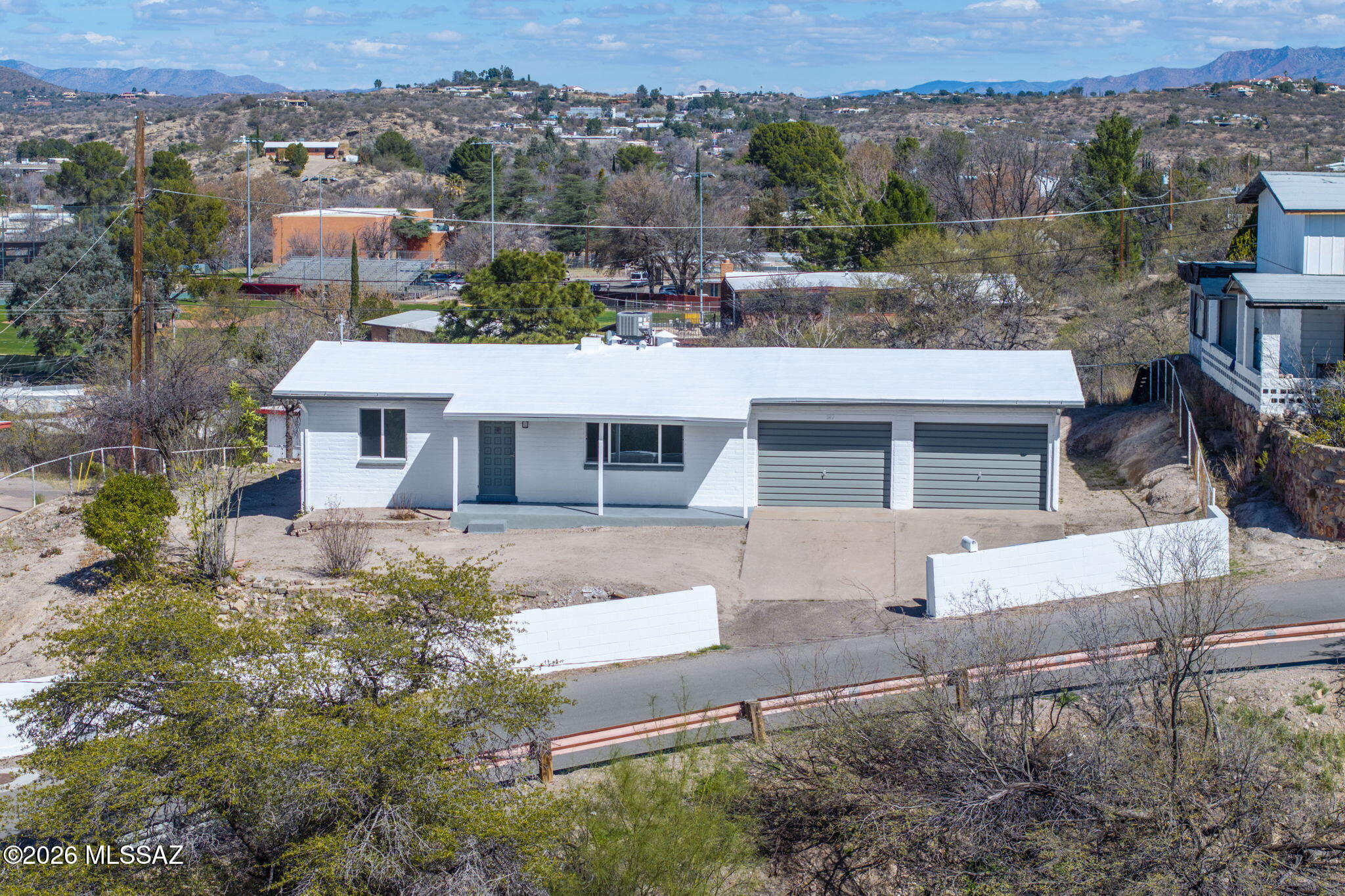 Welcome to 147 E. La Castellana Drive, an immaculately renovated home ideally positioned on a premier hillside lot within one of Nogales' most desirable and well-established neighborhoods. This thoughtfully improved residence offers a strong blend of comfort, functionality, and long-term value, complemented by beautiful panoramic views of the Santa Cruz County Valley. 

The home showcases numerous recent upgrades designed to enhance efficiency and everyday livability. Improvements include fresh interior and exterior paint, new double-pane windows that invite in abundant natural light, updated light fixtures, and a fully modernized kitchen featuring new shaker-style cabinetry, laminate countertops, a stainless range hood, and brand-new appliances highlighted by a gas stove. Bathrooms have been tastefully refreshed with new vanities, modern fixtures, and attractive tile finishes including a spacious walk-in tiled shower with built-in niche and window for natural ventilation, creating clean, contemporary spaces throughout.

Mechanical and infrastructure updates provide additional peace of mind, including an updated electrical panel, new gas water heater, and new split-system air conditioning with an interior natural-gas furnace. The roof has been refinished and enhanced with new drip-edge fascia. The attached two-bay garage offers significant functionality and versatility, featuring a resurfaced and coated floor for a clean, durable finish, exposed beam construction providing structural character and overhead storage potential, and a dedicated laundry area within the garage that also serves as a practical storage and utility room.

Exterior features further elevate the property's appeal, offering a concrete driveway and perimeter security walls with gated access. The expansive hillside lot provides usable yard space with low-maintenance desert landscaping and excellent vantage points to enjoy the surrounding mountain and city views. 

The combination of recent upgrades, functional layout, elevated lot positioning, and established neighborhood setting makes this property well suited for both comfortable owner-occupancy and long-term investment potential in the Nogales market.