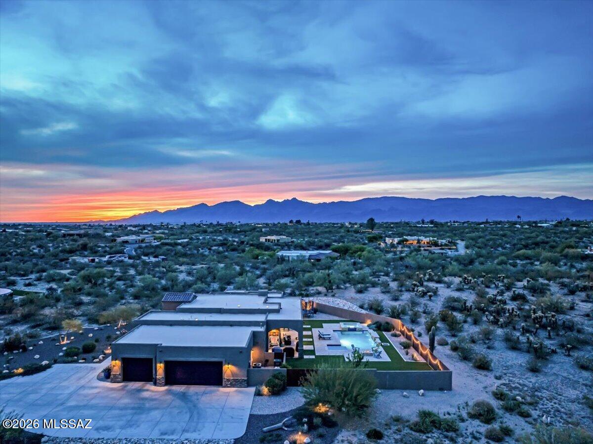 Experience elevated desert living in this exceptional luxury estate. Thoughtfully positioned to capture sweeping views & ultimate privacy, this residence offers a seamless blend of sophistication & serenity. You are welcomed by impeccable craftsmanship, soaring ceilings, & an abundance of natural light that highlights every curated detail. The expansive great room flows effortlessly into a custom kitchen outfitted with top-of-the-line appliances, custom cabinetry, designed for both entertaining & everyday living. The primary suite is a private retreat, featuring a spa-inspired bath & generous walk-in closets. Outside, a resort-style backyard designed for true Arizona living is complete with a sparkling pool, covered patio, and multiple seating areas.