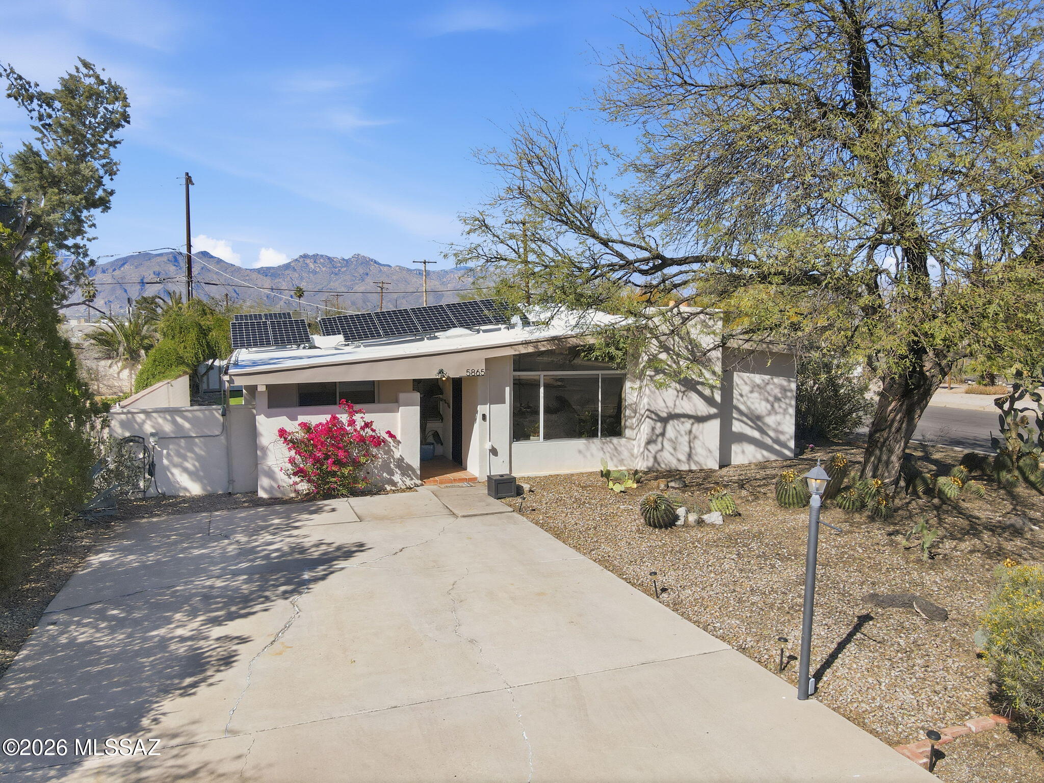 Mid-century charm meets modern efficiency! This 1957 Tucson gem features 3BR/2BA of carpet-free living with tile and LVP flooring throughout. The open kitchen features high ceilings, granite countertops, SS appliances, and flows into two distinct living areas--each anchored by wood-burning stoves. A large bonus Arizona Room offers expansive extra flex space and overlooks your private backyard complete with pool, turf, mountain views and extended side patios. Enjoy energy savings with OWNED SOLAR and a recently updated HVAC system. The property also features an additional storage shed and mature desert landscaping. Centrally located in the Mitman neighborhood near dining, shopping, and amenities. Welcome home!