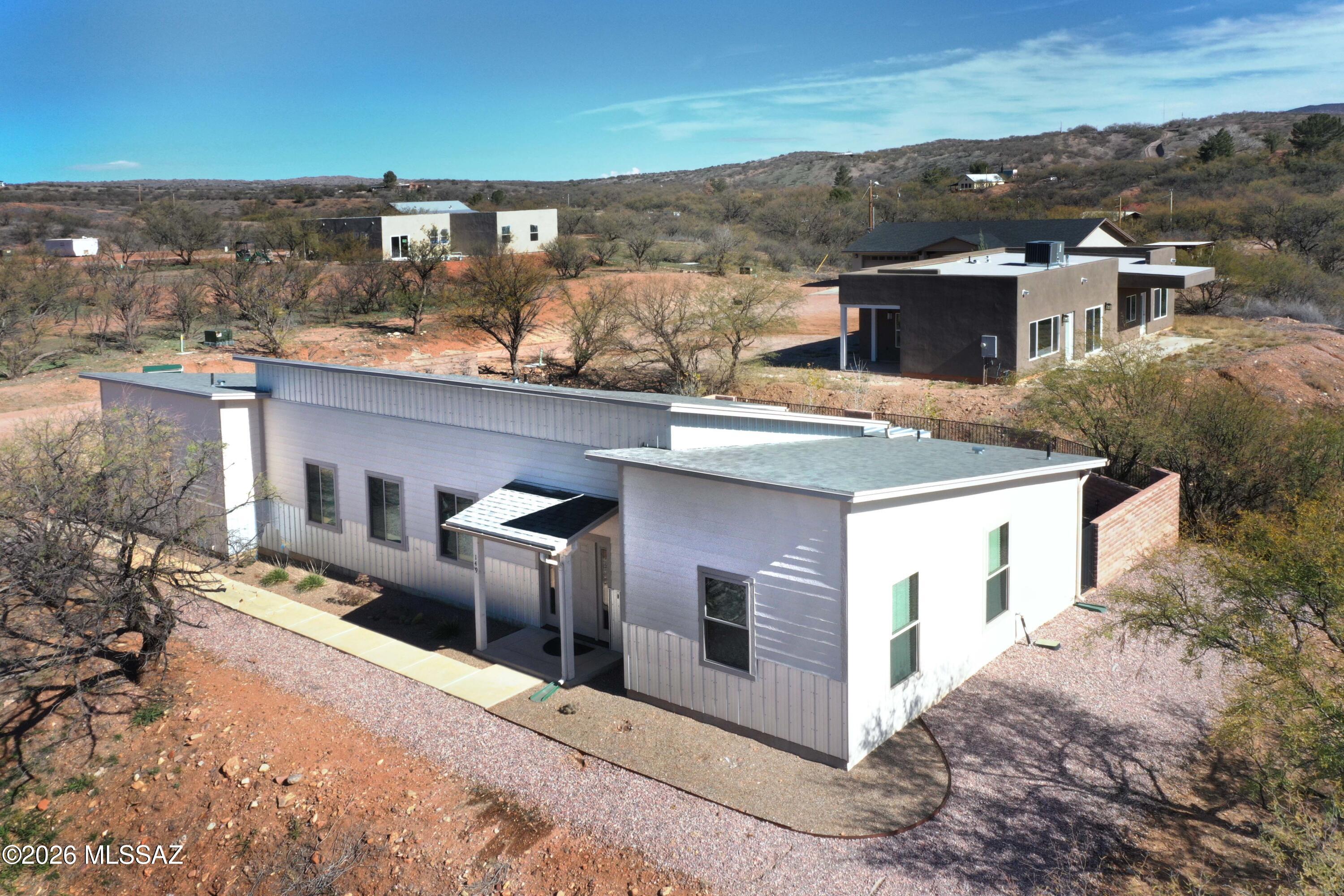 Stylish 1,277sf 2Be/2Ba/2G contemporary home c.2020 on a gentle hill just blocks from the heart of Patagonia, an easy walk to town center! Sitting high on the north side of the village, you'll enjoy stunning mountain, sunset & village views with zero Floodplain concerns. The Seller is the first owner of this thoughtfully conceived 2x6 custom framed, all-electric home.  It's been very gently used, primarily as a weekend residence. Its sunny great room has gracious vaulted ceilings & o/s glass sliders opening to the walled patio-garden area, covered concrete patio & BIG VIEWS! The balance of the home also enjoys unusually high ceilings & handsome granite kitchen & bathroom countertops. The finished garage is smartly vented for heating-cooling & multi-uses. See Docs or call for more details.