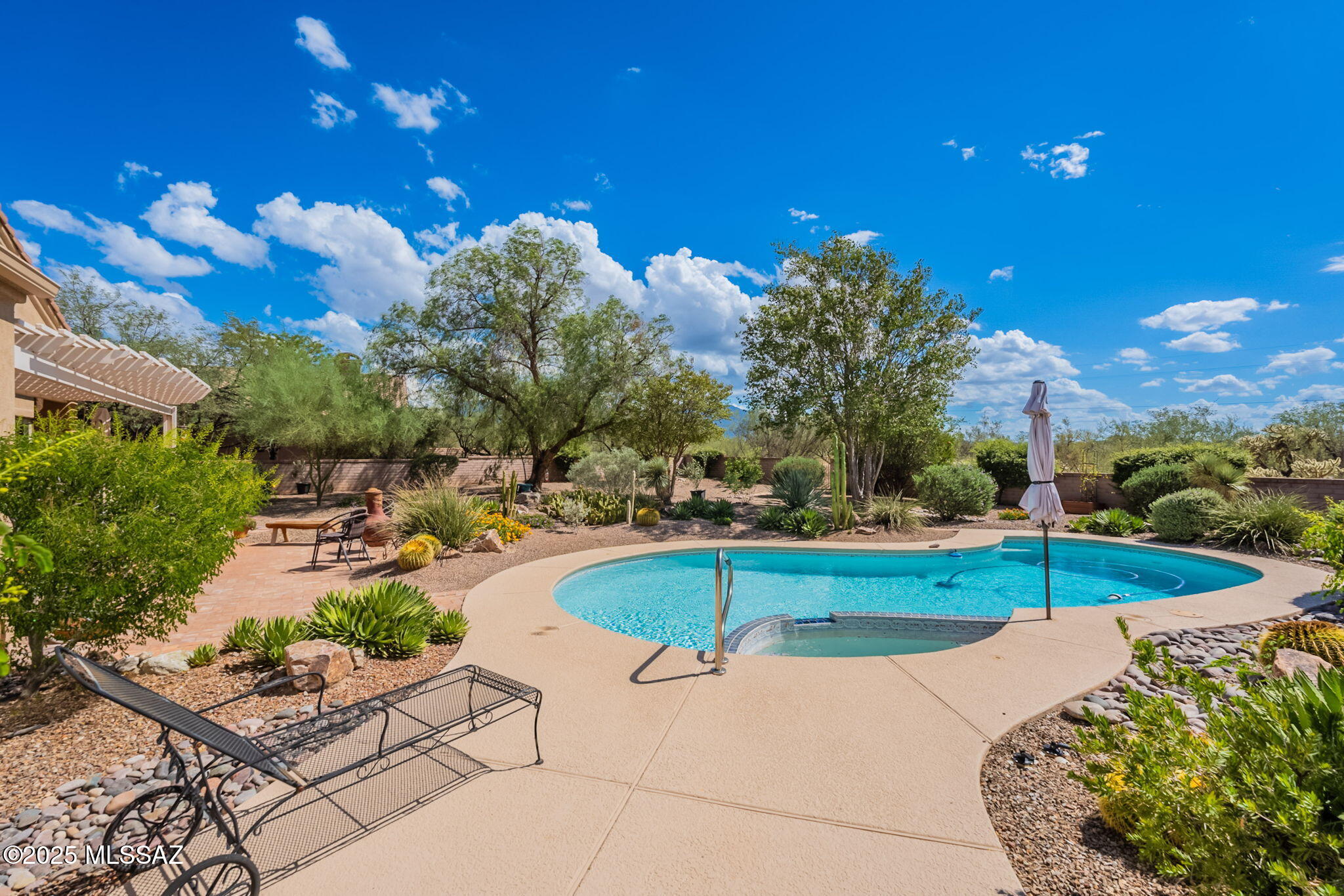 Welcome to this gorgeous home in the prestigious Madera Reserve, a community cherished for its larger lots that provide the perfect blend of privacy, space, and natural beauty. From the moment you arrive, it's clear this home has been lovingly maintained and thoughtfully upgraded, offering true peace of mind for years to come. The exterior was completely repainted in 2020, a brand-new roof was installed in 2024, and the HVAC system—added in 2018 and regularly serviced since—ensures comfort in every season.  The front yard is beautifully landscaped with newer irrigation lines, valves, and controllers, creating a lush, welcoming entrance that immediately feels like home. The oversized 3-car garage is a dream—offering protection for all your vehicles, abundant storage, and plenty of spa for a workshop or hobby area. Even the garage door openers were upgraded in 2023, proving no detail has been overlooked.  Step onto the grand entry porch, where your guests will be impressed to an open, light-filled floor plan. With sightlines that stretch across the dining room, library, kitchen, and living room, the home feels expansive and inviting. New windows throughout (2022) flood the space with soft natural light, highlighting every corner. The living room, complete with a cozy gas fireplace, is perfect for hosting friends, curling up with a book, or enjoying a relaxing movie night.  The kitchen is a true centerpiece, designed with both form and function in mind. Two spacious islands, endless cabinet storage, and appliances replaced in 2019 make it the ideal space for the family chef. Whether you're preparing weeknight dinners or hosting holiday feasts, this kitchen delivers. The laundry room, with an LG washer and dryer added in 2018, makes daily chores a breeze, while the 2021 water softener system protects your appliances and ensures every shower feels luxurious. For added peace of mind, even the smoke detectors were replaced in 2022.  With 3 guest bedrooms and a spacious primary suite, this home adapts perfectly to your lifestylewhether you're raising a family or welcoming friends and loved ones to the desert. Two well-appointed guest bathrooms offer plenty of space and comfort, while the primary bathroom feels like a retreat with its remodeled shower (2021), generous size, and separate vanities.  The backyard is where this home truly shines. Step out under the stylish aluminum pergola and onto the extended paver patio, perfect for outdoor dining, morning coffee, or sunset gatherings. The heated pool, with refreshed decking (2018), a new heater and variable speed pump (2018), and sand filter (2022), promises year-round enjoyment. The entire yard is fully enclosed with slump block walls for privacy, and it backs up to common area, giving you a peaceful buffer and uninterrupted views of the majestic Santa Rita Mountains.  Day or night, the setting is spectacular. Watch vibrant Arizona sunrises paint the mountains in fiery hues, enjoy peaceful afternoons in your private oasis, and then settle in under the famous star-filled skies that make our desert evenings so unforgettable.  This is more than just a houseit's a lifestyle, a retreat, and a home that truly has it all. Come see for yourself why this property in Madera Reserve is one you won't want to miss.