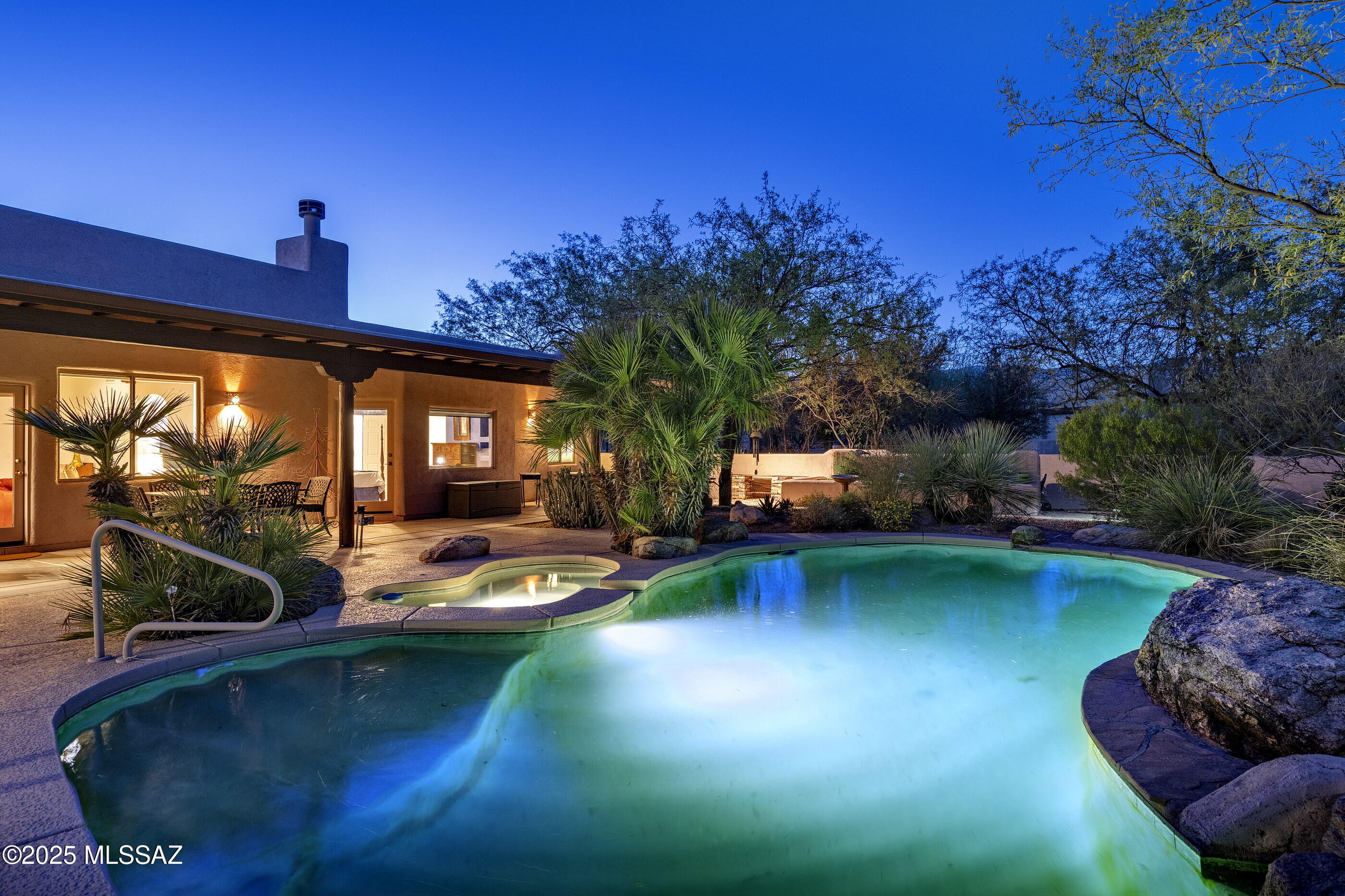 A private desert oasis, wrapped in a thoughtfully designed garden featured in publishing, a sanctuary of native plantings, a charming courtyard, pool, spa, and dancing mountain views awaits. Entertain from the relaxing patios and easily transition inside to the formal living, dining, or family areas. Overlook the lush gardens and fireplace in the family room from the gorgeous kitchen. Retreat to one of four bedrooms, arranged in a split floorplan (2 on each side). The grounds were created with ease of maintenance in mind, equipped with irrigation, rainwater harvesting, and even raised garden beds.