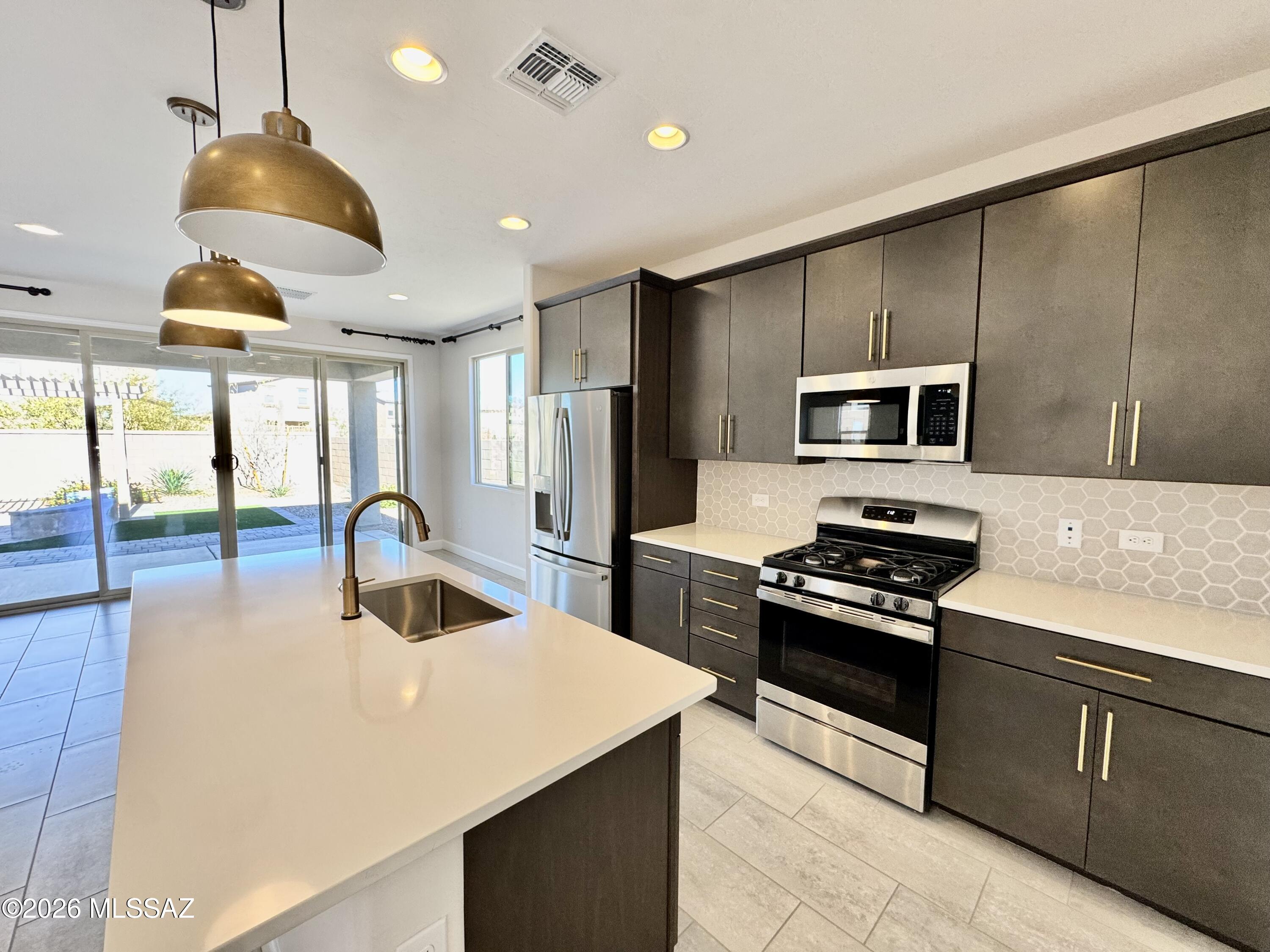 This Moonstone model home is a must-see! Included features: a private study; a convenient powder room; an open great room with an eye-catching fireplace; a well-appointed kitchen boasting maple cabinets, white quartz countertops, a center island with brass pendant lighting, a walk-in pantry, stainless-steel appliances, a dining nook and an adjacent covered patio; an upstairs laundry; a versatile loft; an elegant primary suite showcasing a private bath with a barn door and an expansive walk-in closet; three secondary bedrooms, including one with a walk-in closet; a shared bath and a 2-car garage. This home also offers additional windows in several rooms, stone exterior accents and backyard landscaping with a pergola.