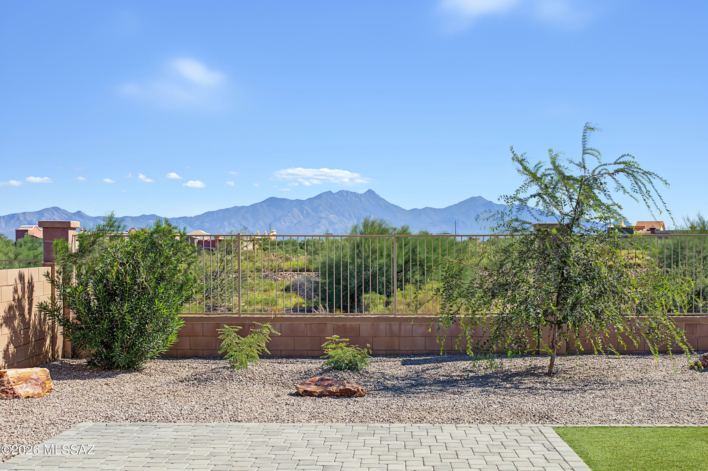 Seller will contribute $10,000 toward buyer's rate buy down or closing costs with an acceptable offer! Built in 2019, this spacious 6 bedroom Rancho Sahuarita home combines flexible living with an incredible mountain backdrop. A downstairs bedroom and an adjacent full bath provide an ideal setup for multigenerational living, guests, or a home office. The heart of the home is the huge great room, where center meet doors frame the stunning mountain view and allow natural light to flood the space. The kitchen offers plenty of room to gather along with a generously sized walk in pantry. Fresh interior paint and brand new carpet make this home truly move in ready. Step outside to what may quickly become your favorite part of the home! The backyard features an extended covered patio, pavers, low maintenance turf, and a view fence showcasing gorgeous mountain scenery. Enjoy all that Rancho Sahuarita has to offer including pools, a splash park, clubhouses, gyms, sports courts, trails, a lake, parks, and a variety of planned activities for all ages. With six bedrooms, flexible living space, and a view you'll never get tired of, this home has room for everyone!