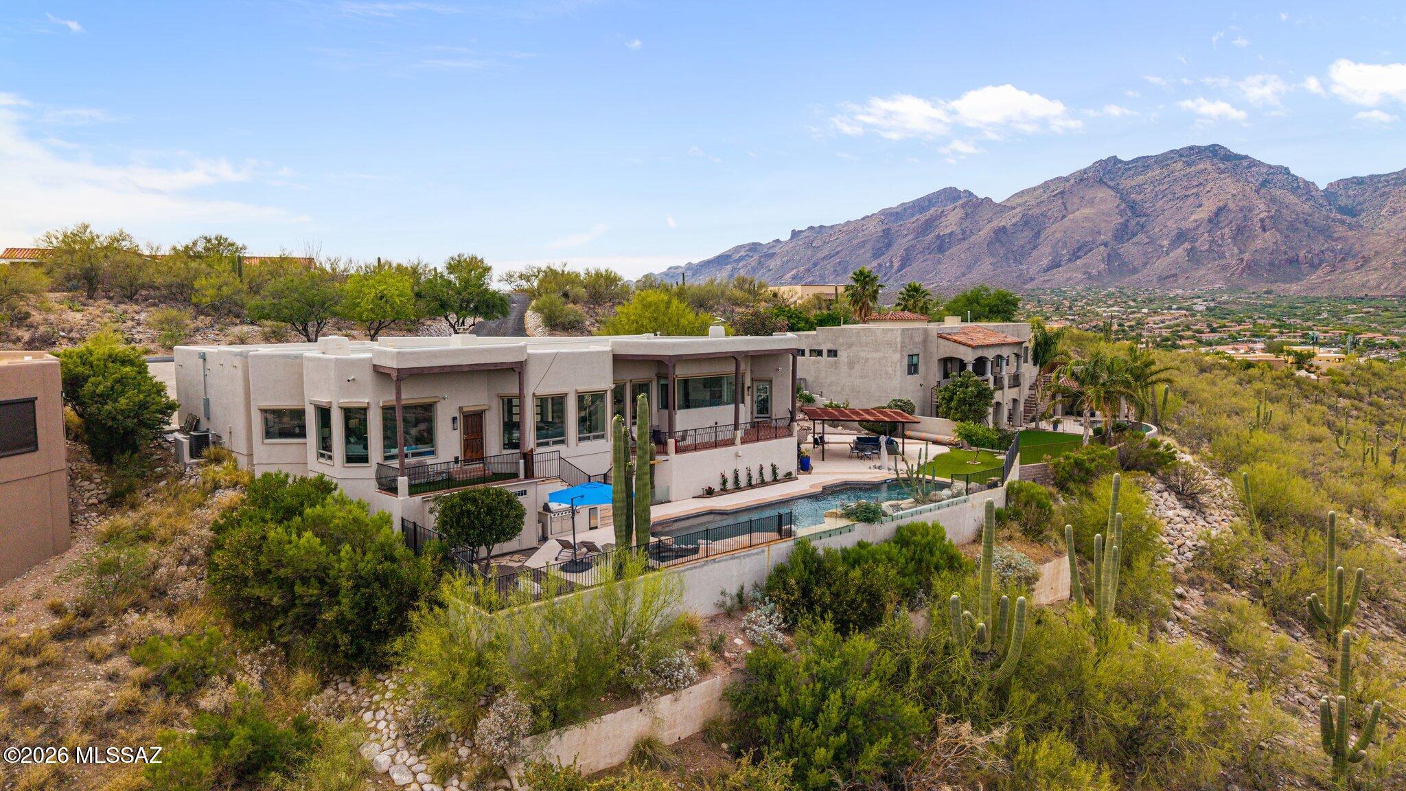 Perched high on the ridgeline in Summit Ridge Estates, this private Tucson retreat captures unobstructed, jaw-dropping east-facing views of the Santa Catalina & Rincon Mountains. Enjoy endless desert skies just minutes to Ventana Canyon, premier golf, shops & dining. Lightly lived in as a second home, it has been lovingly maintained with $200K+ in upgrades. An entertainer's kitchen anchors the home, while expansive windows frame the stunning Tanque Verde Valley throughout. Outdoor living shines with a 20-yard lap pool, heated spa, 1,000+ sq ft of covered patios, and a custom 20x20 metal gazebo with solar lighting. Complete with an outdoor kitchen featuring sink, fridge & chef's grill--perfect for effortless evenings under the desert sky. Notable Additions and improvements; a Generac generator along with enclosure & expanded SW Gas line, new pool cover, restoration of balcony supports, solar ground lighting, roof resealing, rehung interior doors, glass pool fencing, & California Closet/Murphy bed installed, Room darkening Security Blinds and Automatic Screen shades on East facing windows of Kitchen, Living spaces