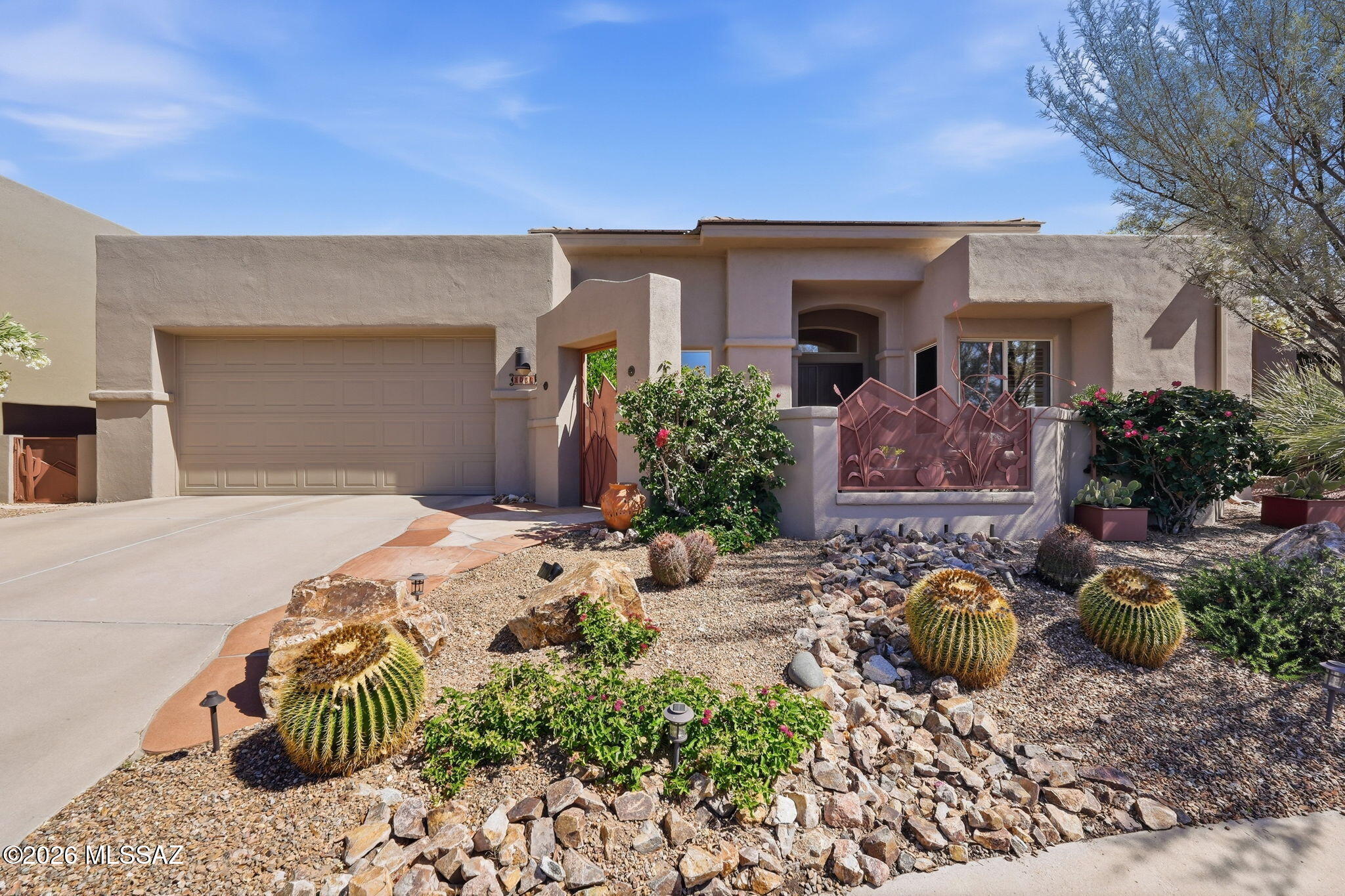 Enjoy privacy, breathtaking mountain views, and refined living in this beautiful home, backing to a nature preserve in a sought-after Oro Valley community. A charming courtyard with custom ironwork sets the tone and welcomes you inside.  Walls of windows flood the interior with light (N/S exposure), while new bedroom flooring and no carpet throughout create a clean, modern aesthetic. Improvements include a new roof, fresh interior paint, stylish light fixtures, updated window coverings, and new appliances. The backyard features a flagstone covered patio, built-in BBQ and unique fire feature. A back gate opens directly to walking/bike paths within the nature preserve, offering access to the surrounding natural beauty. Set in a tranquil, view-filled location--this home truly has it all!