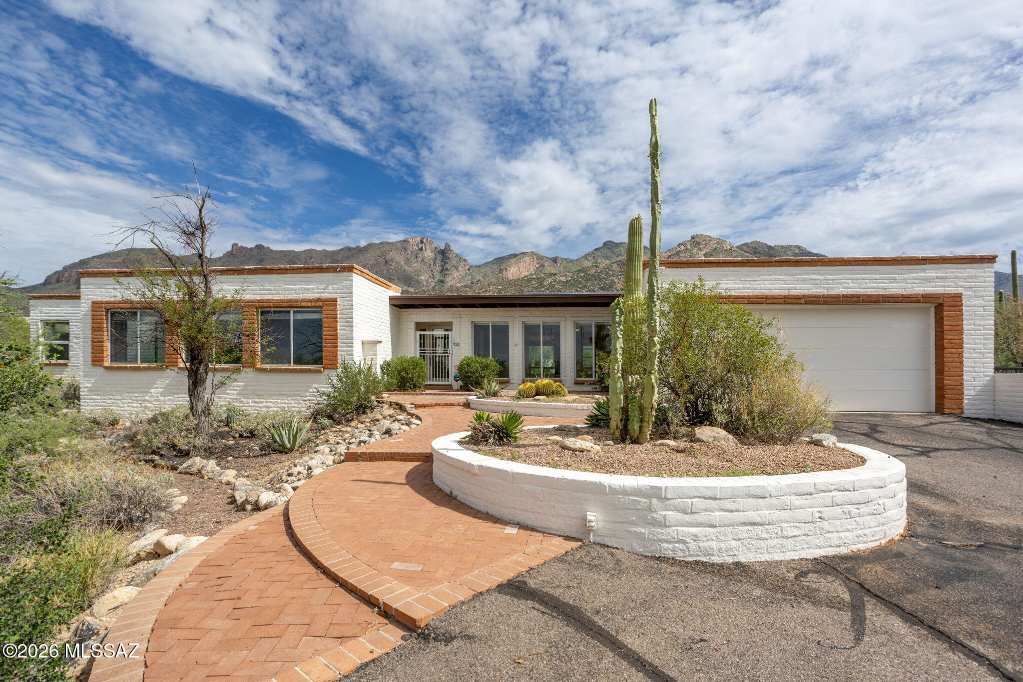 Peace, privacy, and mountain & city lights views from this 4 spacious bedrooms/3 full bathrooms burnt adobe territorial-style home on nearly one acre resembles the Tucson lifestyle so coveted.  A chef's kitchen features gas cooking, cabinets aplenty and a large island.  The front rooms are spacious and suitable for a game room and entertaining.   Exterior features include a Pebbletec pool & spa, a brick patio, roll-up shutters, seller-owned solar, and a recently re-coated rooftop.  Low HOA dues and top-rated Catalina Foothills 16 school district complete the offering.