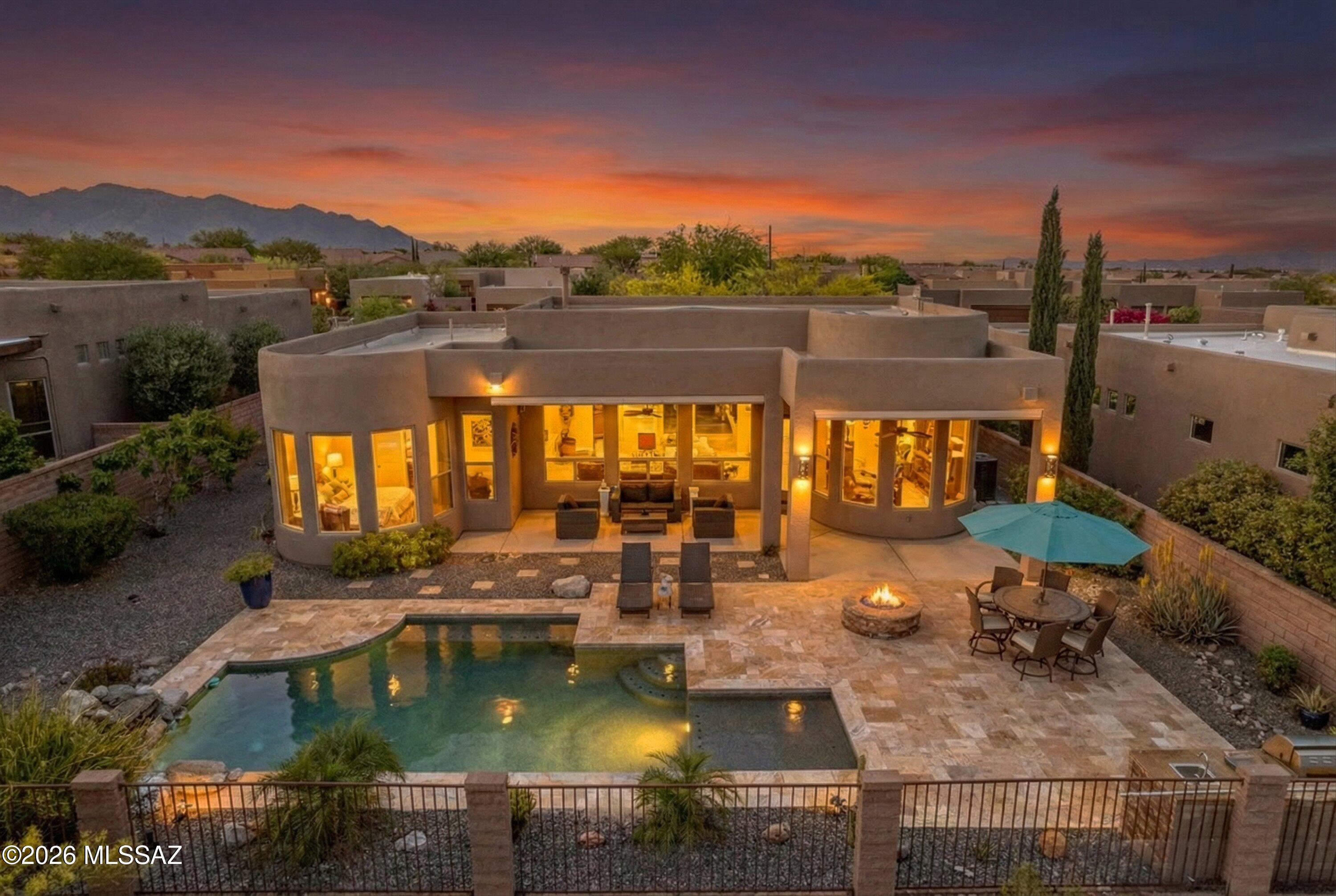 Stunning Insight-built Santa Fe masterpiece in gated Preserve III at Dove Mountain.
 This exceptional 3-bedroom, 3-bathroom residence spanning 2,204 sq ft seamlessly blends timeless Southwestern architecture with elevated design, offering breathtaking mountain, desert, and sunset views from nearly every angle.
From the moment you arrive, the home makes a statement. A private walled courtyard entry--framed by wrought iron and desert landscaping--creates a serene arrival experience, while the distinctive copper-paneled 3-car garage showcases a rich, natural patina rarely found in homes of this kind. Every detail speaks to quality, craftsmanship, and intentional design.
Inside, soaring ceilings immediately open the space, while expansive windows frame the Tortolita Mountains and flood the home with natural light throughout the day. Polished concrete floors run throughout the main living areas, reflecting light and adding a sophisticated, modern contrast to the home's warm Southwestern character. A striking beehive fireplace anchors the great room, creating a space that feels both inviting and architecturally significant--perfect for everyday living or elevated entertaining.
The open-concept design flows seamlessly into an entertainer's kitchen where custom alder cabinetry extends to the ceiling in a rich finish, complemented by dark granite countertops and a mosaic tile backsplash. A large island with prep sink and bar seating becomes the natural gathering point, while the appliance suite--including gas cooktop, convection oven, and professional hood--offers both beauty and performance. Clerestory windows bring in additional natural light, enhancing the warmth and openness of the space.
Designed for both privacy and functionality, the split-bedroom floor plan places the primary suite in its own wing. This private retreat features a bay window sitting area ideal for quiet mornings or evening unwinding. The ensuite bathroom is thoughtfully designed with dual separate vanities, a soaking tub set in large-format porcelain tile, and a spacious walk-in shower complete with bench seating and built-in niches--delivering a true spa-like experience.
Secondary bedrooms are positioned on the opposite side of the home, offering comfort, privacy, and generous natural light. A well-appointed guest bathroom with dual vanities and full tile surround, along with a convenient powder room, ensures both residents and guests are equally accommodated. A dedicated laundry room with sink, storage, and included washer and dryer adds everyday practicality, along with a whole-home water softener system.
Step outside and the home transforms into a resort-style retreat. A sprawling travertine patio creates multiple outdoor living spaces, centered around a heated saltwater pool with waterfall feature that brings both movement and tranquility to the backyard. A stone gas firepit invites evening gatherings, while the built-in outdoor kitchen with grill, prep space, and sink makes entertaining effortless. Mature desert landscaping, fruit trees, and low-maintenance design enhance the setting, while a wrought-iron view fence preserves unobstructed desert and mountain views--delivering truly unforgettable sunsets.
Located within one of Dove Mountain's most desirable gated communities, Preserve III offers walking trails, parks, and access to highly regarded schools, all while providing convenient proximity to I-10, premier golf courses, dining, and the best of Northwest Tucson.
This property has been brought to market with a level of presentation reserved for homes that truly deserve it. Homes of this caliber, in this setting, and presented this way do not come available often.
Private showings available by appointment. Schedule yours today.