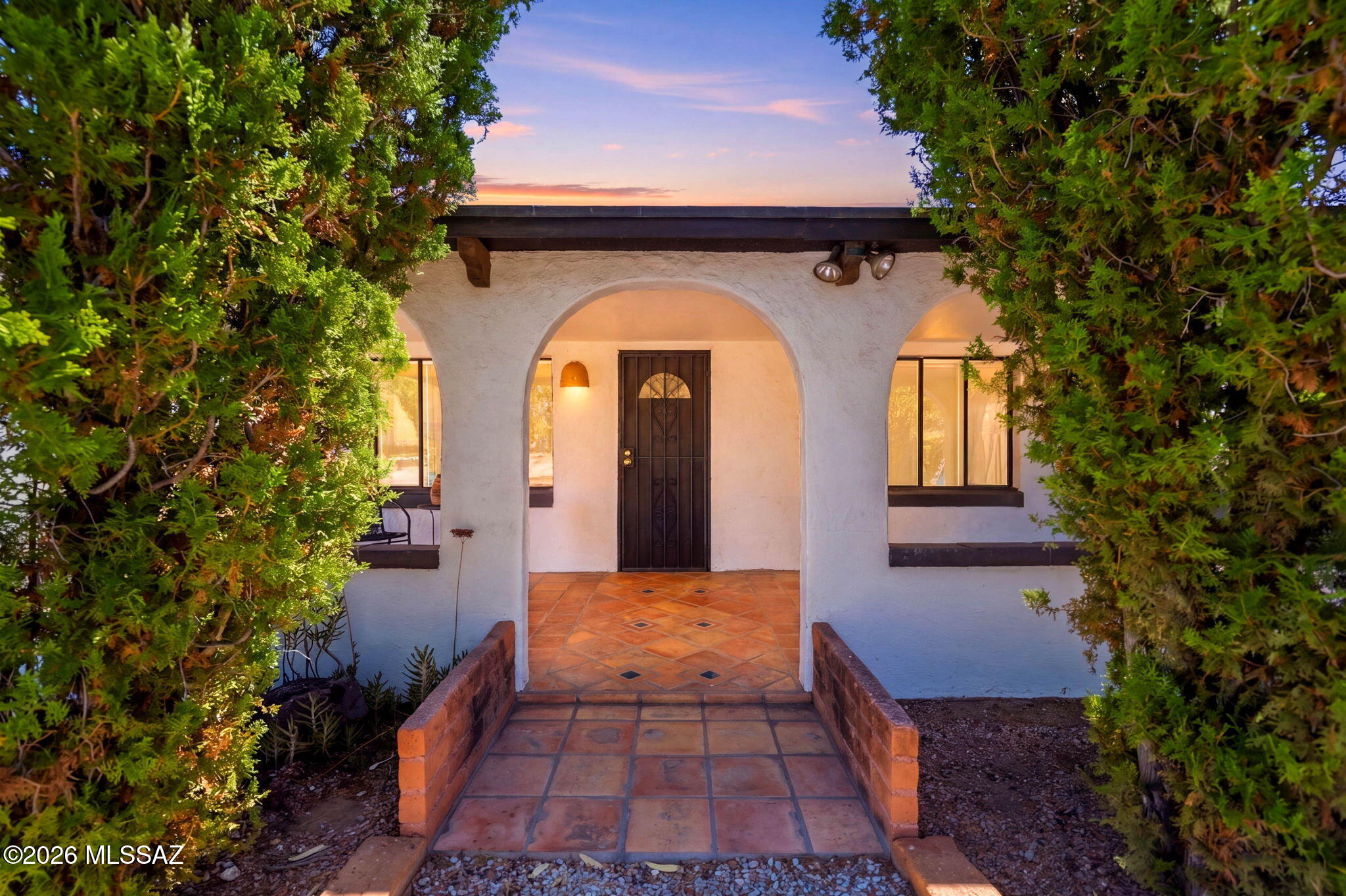 This one is special. Full of warmth, character, and the kind of charm that's getting harder to find. Saltillo tile floors, arched details, built-ins, and a cozy wood-burning fireplace give the home that authentic Tucson feel, while the updates that matter have already been done. The kitchen has been beautifully remodeled with butcher block countertops, updated cabinetry, open shelving, and stainless steel appliances, and the bathrooms have been tastefully refreshed as well.

The home is currently set up as 2 bedrooms plus an additional bonus room with its own window AC unit that could easily work as a third bedroom, office, studio, workout room, or guest space depending on your needs.

Outside, you'll find a large private yard with mature cactus landscaping, covered patio space, fire pit area, and room to truly enjoy the outdoors. Two covered carports, extra storage, and space for RV parking are an added bonus.

Located in the heart of central Tucson near the Rillito River path, UofA, parks, restaurants, and shopping, this home blends character, comfort, and functionality in a way that feels inviting the moment you walk in.