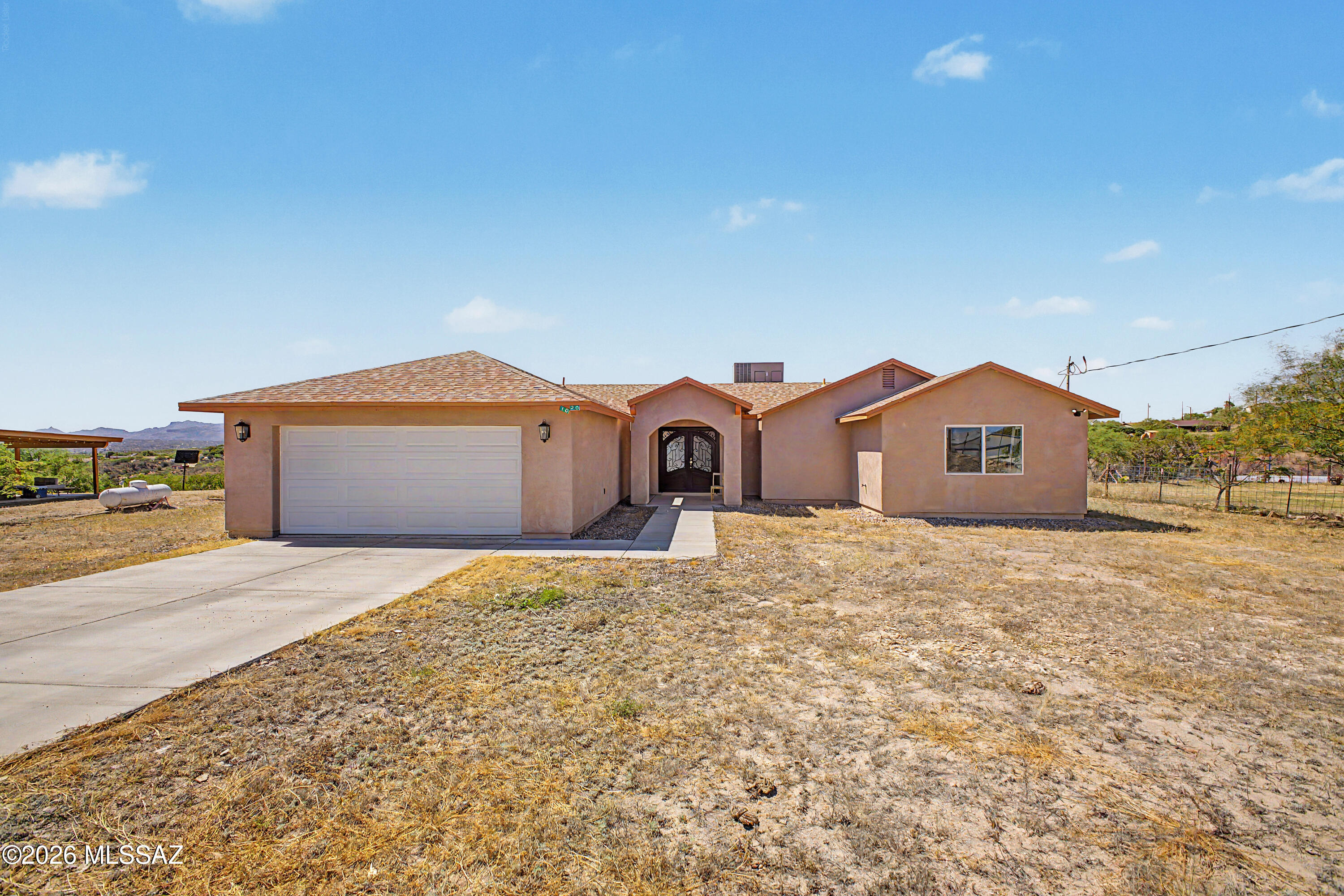 Assumable loan available--don't miss this rare opportunity in Rio Rico! Location is everything, and this home is ideally situated just minutes from the I-19 freeway for fast and convenient access. Inside, you'll find a bright open floor plan with a large kitchen showcasing granite countertops, a custom iron entry door, and stylish ceramic tile flooring throughout. The home includes three spacious bedrooms, each with walk-in closets for ample storage. Set on a full acre, the property offers endless potential for outdoor living. Enjoy stunning views with beautiful sunrises in the front and vibrant sunsets in the back.