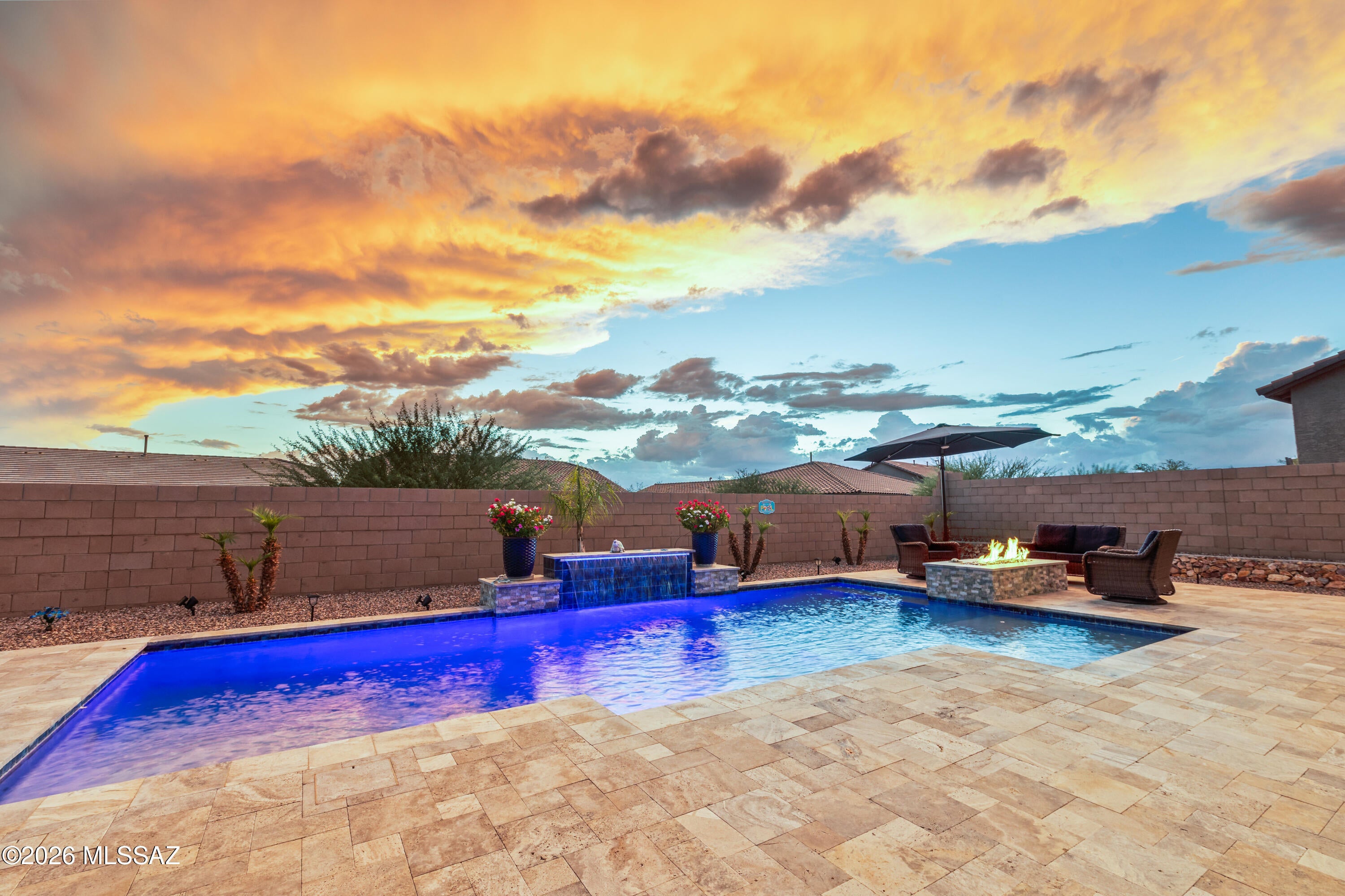 Your own backyard retreat awaits! This beautifully maintained home offers inviting indoor spaces that flow effortlessly to an impressive outdoor setting. Step outside to a sparkling pool surrounded by an expansive travertine patio, artificial turf, and plenty of room to relax, entertain, or soak up the Arizona sunshine. A covered patio provides a shaded spot for outdoor dining and lounging. Inside, enjoy a bright, open layout with a spacious kitchen, generous island seating, and comfortable living spaces. A wonderful home designed to make the most of indoor-outdoor living.