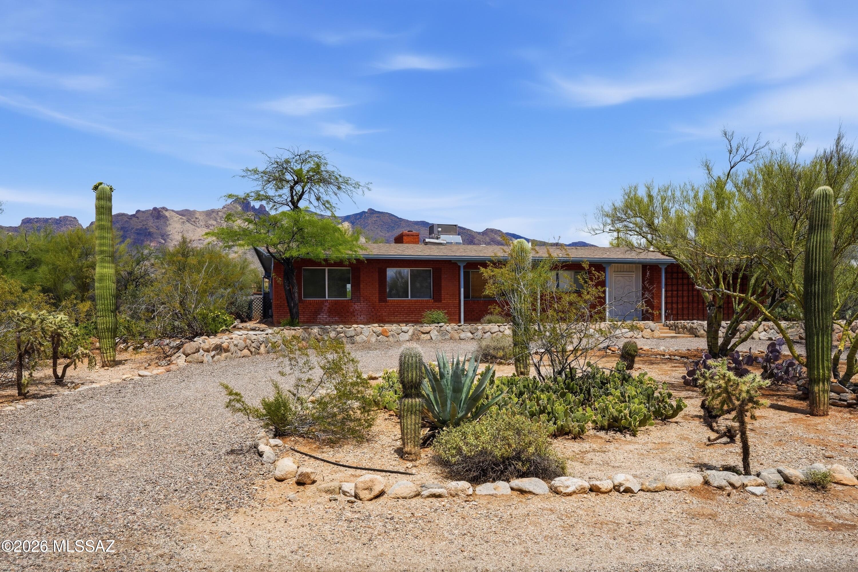 This wonderful Foothills home is your diamond in the rough. It's classic foothills territorial-style lines hide a beautiful layout inside. From the large family room with mountain views to a split bedroom floor plan featuring two en-suite guest rooms and a private primary bedroom, this home offers both comfort and character. Features include a wood-burning fireplace a large picture window showcasing desert and mountain view, a walk-in pantry, and abundant storage throughout. This home offers a rare opportunity just minutes from amenities like La Encantada and St Philip's Plaza. All this house need is you.
