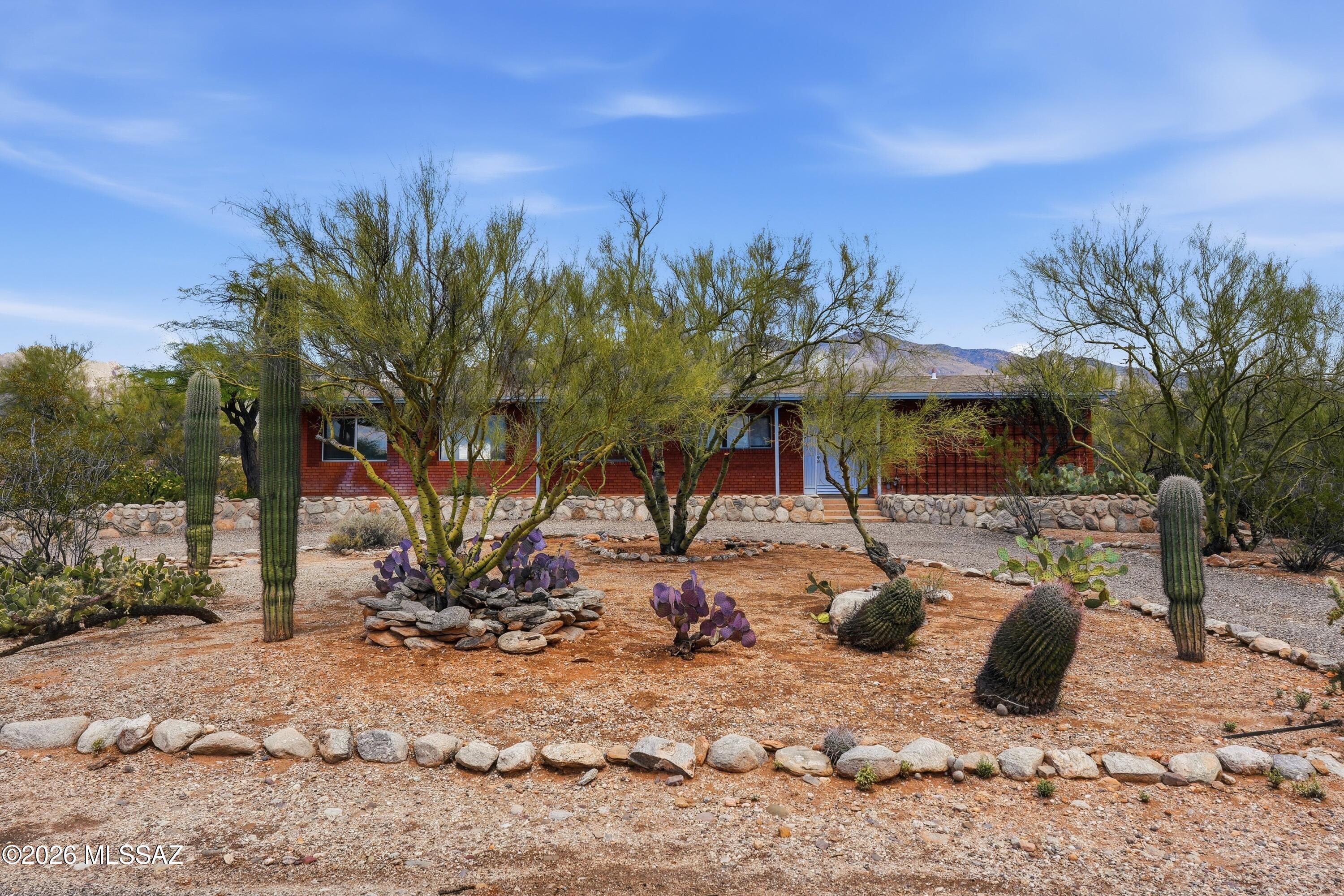 This wonderful Foothills home is your diamond in the rough. It's classic foothills territorial-style lines hide a beautiful layout inside. From the large family room with mountain views to a split bedroom floor plan featuring two en-suite guest rooms and a private primary bedroom, this home offers both comfort and character. Features include a wood-burning fireplace a large picture window showcasing desert and mountain view, a walk-in pantry, and abundant storage throughout. This home offers a rare opportunity just minutes from amenities like La Encantada and St Philip's Plaza. All this house need is you.