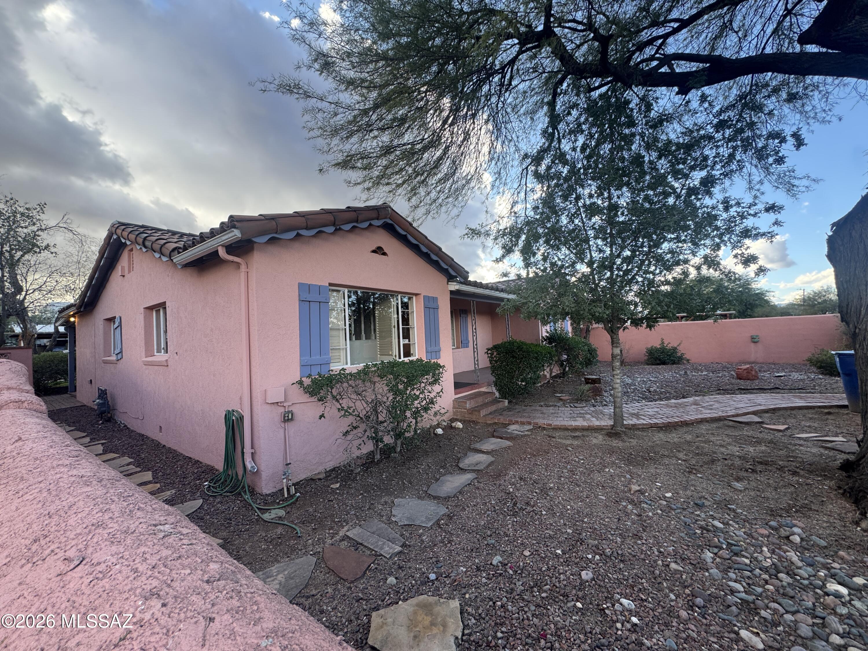 Exceptional corner-lot property in the heart of Jefferson Park, just steps from the University of Arizona. This lovingly cared-for home features a spacious 4-bedroom, 2-bath main residence plus a detached 2-bedroom guest house with tasteful updates, a 2-car garage, and a stunning private courtyard—ideal for rental income, guests, or multigenerational living. The main house offers a flexible floor plan with a large family/game room, separate living room, spacious kitchen, bonus room/office, and four bedrooms, including a smaller bedroom with a closet perfect for an office or study. Recently upgraded. Fully enclosed front and backyard spaces create a peaceful, park-like retreat in an unbeatable walkable location near U of A