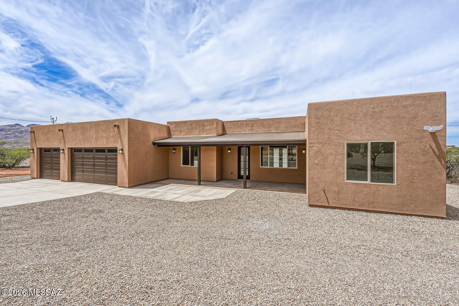 Welcome home! Newly constructed modern elegance on over 1/2 an acre of level,  land. Enjoy beautiful views of Tumacacori Mountains. Home features an oversized 3-car garage & over 2,000 sq ft of thoughtfully designed living space.  Expansive layout offers a split-BR plan for added privacy.  Open kitchen /G R form the heart of the home, featuring quartz countertops, custom handcrafted Alder wood cabinetry, & porcelain wide-plank flooring throughout, w/ abundant natural light. Soaring 10-ft ceilings enhance the spacious feel, complemented by a sleek linear recessed fireplace. Enjoy the excellent year-round weather of Rio Rico from the end-to-end covered rear patio & a spacious front entrance porch, perfect for relaxing or entertaining under star-filled night skies. W/ views, design, & locat