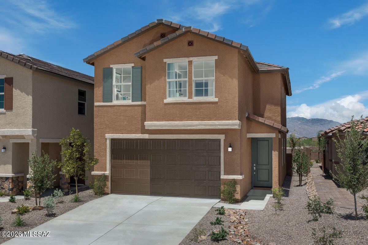 This two-story, former model home features front yard landscaping with dry river bed rock, backyard landscaping, a 9-ft. first-floor ceiling, designer art and window treatments, and wood-look porcelain tile flooring throughout. Overlooking the spacious great room, the kitchen boasts white cabinets, an island, walk-in pantry, and Whirlpool® stainless steel appliances. Upstairs, the loft provides flexible living space. The primary bedroom showcases a neutral wallpaper accent wall, walk-in closet, and connecting bath with a dual-sink vanity and walk-in shower. Bedrooms 2 and 3 include designer accent walls. The landscaped backyard includes pavers, turf grass, and a covered back patio with views of the Rincon Mountains. Price includes discount predicated on using seller's preferred lender KBH