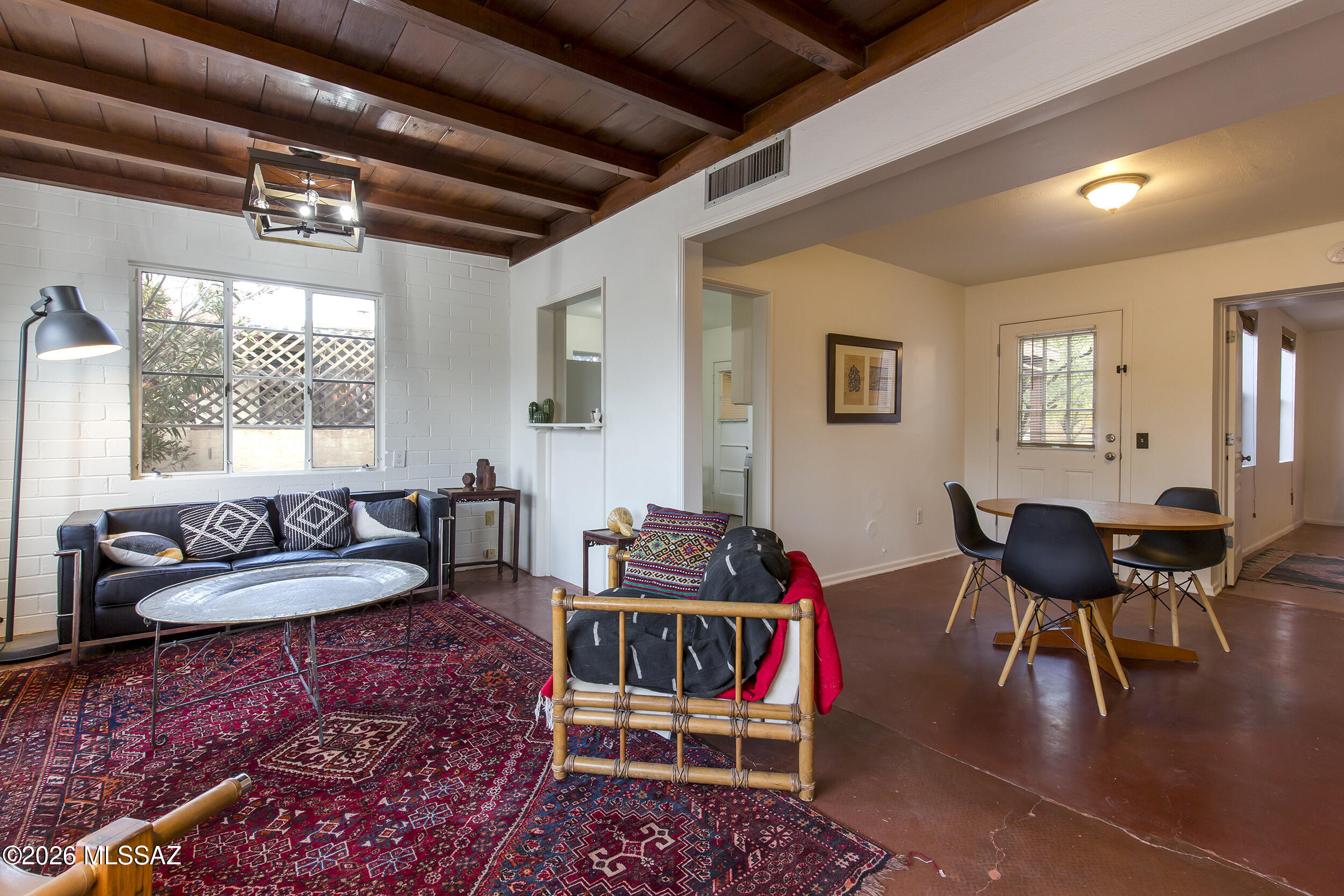 Located in the San Gabriel neighborhood, this charming 1949 bungalow blends original character with a well-balanced floor plan and thoughtful addition. Wood-beamed ceilings and polished concrete floors anchor the main living spaces, with a defined living room that opens into a central dining area, creating a natural flow for everyday living.

The kitchen sits just off the dining room, with direct access to a dedicated laundry/utility room and rear patio, allowing for easy indoor-outdoor connection. The original bedroom and hall bath are set toward the front of the home, while the primary suite addition is privately positioned at the rear. Generous in scale, the primary offers high ceilings, a walk-in closet, and an en-suite bath.

An enclosed entry adds a sense of arrival, while the la corner lot--shaded by mature mesquite trees--provides a spacious yard with room to expand or further enhance outdoor living. Just blocks from Reid Park and close to neighborhood parks, shopping, and schools, the location combines convenience with a strong neighborhood feel.