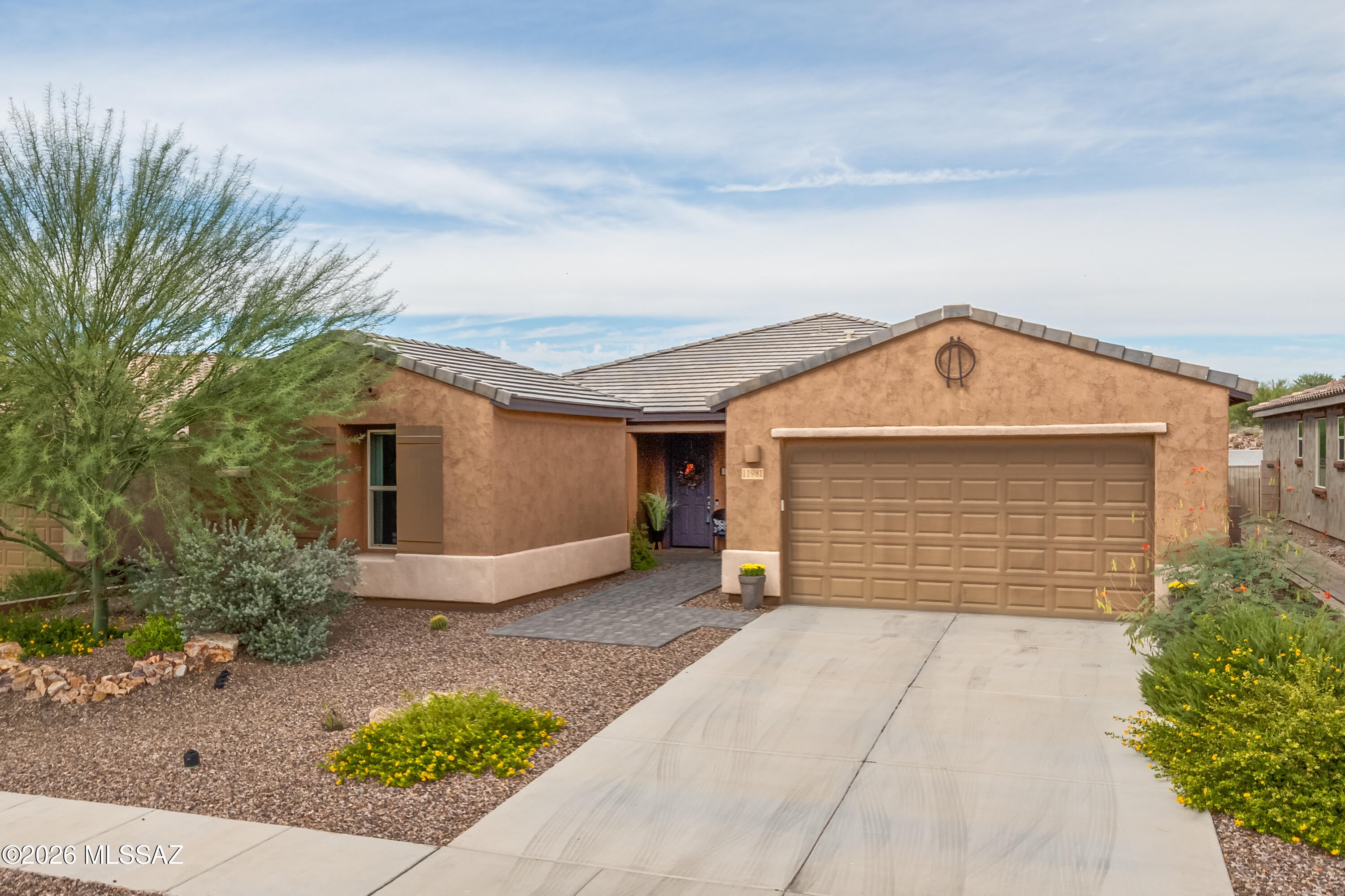 Situated in the gated Villages at Silverhawke, ideally located in the heart of Oro Valley and surrounded by preserved open space and the natural beauty of the Sonoran Desert. Built in 2021, this beautifully appointed 2,588sf single-story 3BR/2½BA+den and 3-car garage, all set on a premium cul-de-sac lot with no neighbors directly behind. A brick-paver walkway welcomes you inside to a spacious open floor plan filled with stylish finishes and everyday conveniences. Impressive kitchen is the heart of the home, featuring quartz countertops, abundant cabinetry with soft-close doors and roll-out shelving, large center island with breakfast bar, custom backsplash, Bosch induction cooktop, upgraded stainless appliances & generous walk-in pantry. Adjoining dining area & great room provide plenty of room for gathering and entertaining. Double doors open to a versatile den ideal as a home office and additional guest space. 2nd BR has king size murphy bed frame. BR 2 & 3 share Jack & Jill Bath. Spacious primary suite is a private retreat with an oversized bath featuring a custom walk-in shower, dual sinks and an exceptionally large walk-in closet. Power blinds with remotes add convenience and comfort throughout the home. Designed for enjoying the Arizona lifestyle, the backyard features low-care landscaping, an extended brick-paver patio with sunshade, built-in BBQ, and mature lemon and tangelo trees. With open space behind, the setting offers an added sense of privacy and connection to the surrounding desert. Additional features include a water softener, kitchen water filtration system and a 3-car garage with epoxy-coated flooring and an Enel X Level 2 EV charging station. Villages at Silverhawke offers beautifully maintained common areas, neighborhood parks, two playgrounds, a basketball court, covered picnic areas, sidewalks and walking trails, all framed by the spectacular Catalina Mountains. Enjoy convenient access to Naranja Park, The Loop, Catalina State Park, hiking and biking trails, golf, shopping, dining and medical services. A wonderful combination of newer construction, thoughtful upgrades, a premium homesite & exceptional Oro Valley location