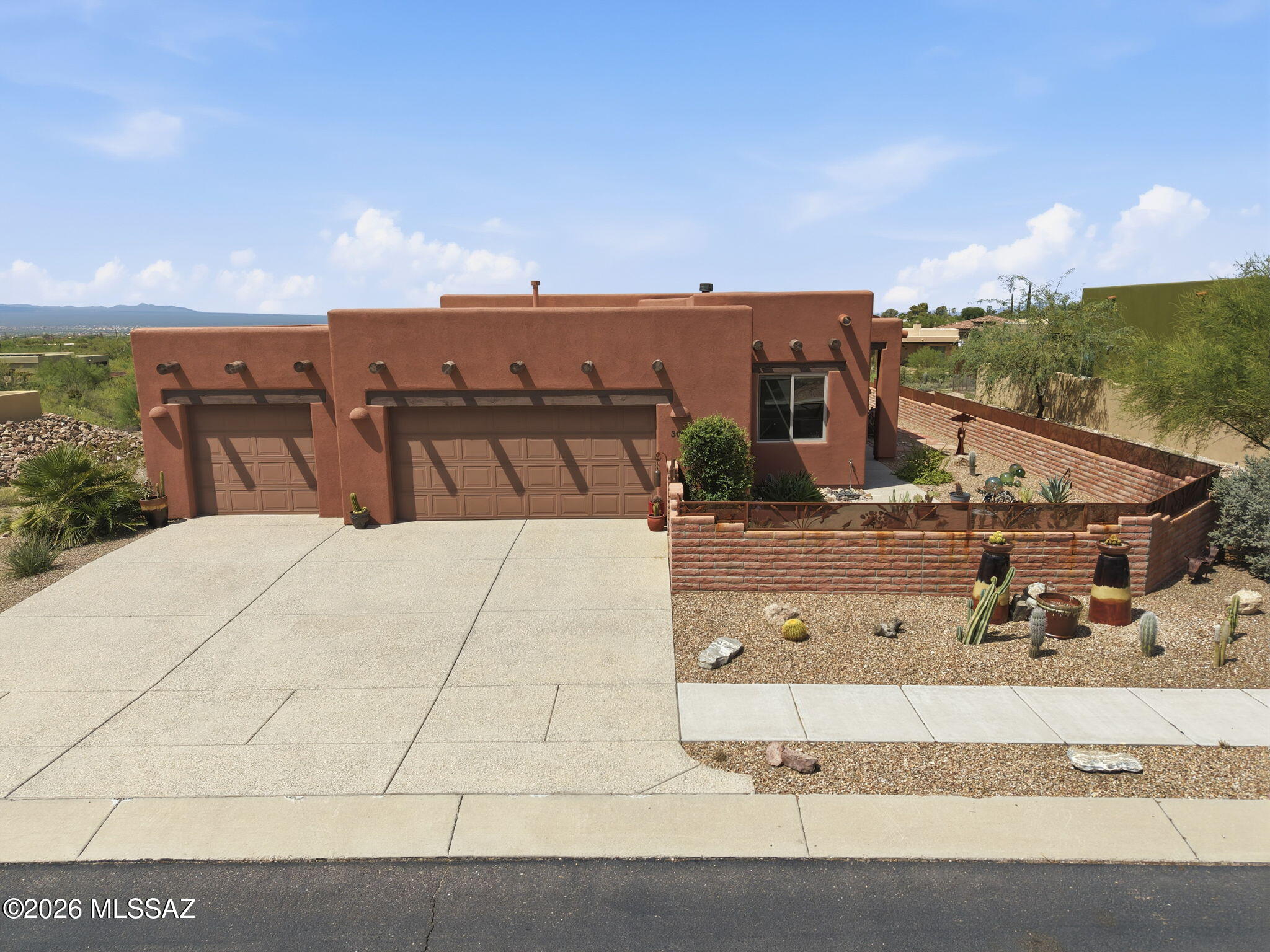 Welcome to Starr Ridge, a premier community nestled in the Tucson Mountains. This highly upgraded Santa Fe-style home was designed & built by John Herder. Quality craftsmanship and custom details are showcased throughout, including soaring ceilings, upgraded windows, knotty alder cabinetry and stunning granite countertops. The extended great room features a corner beehive fireplace and plenty of natural light, while the split-bedroom floor plan provides privacy. Additional features include a 4-foot extended garage with epoxy flooring, fully fenced yard, water softener and new gas water heater (Jan  2025. Starr Ridge offers a neighborhood pool and spa, with scenic hiking & biking trails just around the corner. Enjoy privacy, character and the beauty of the Tucson Mountain living!