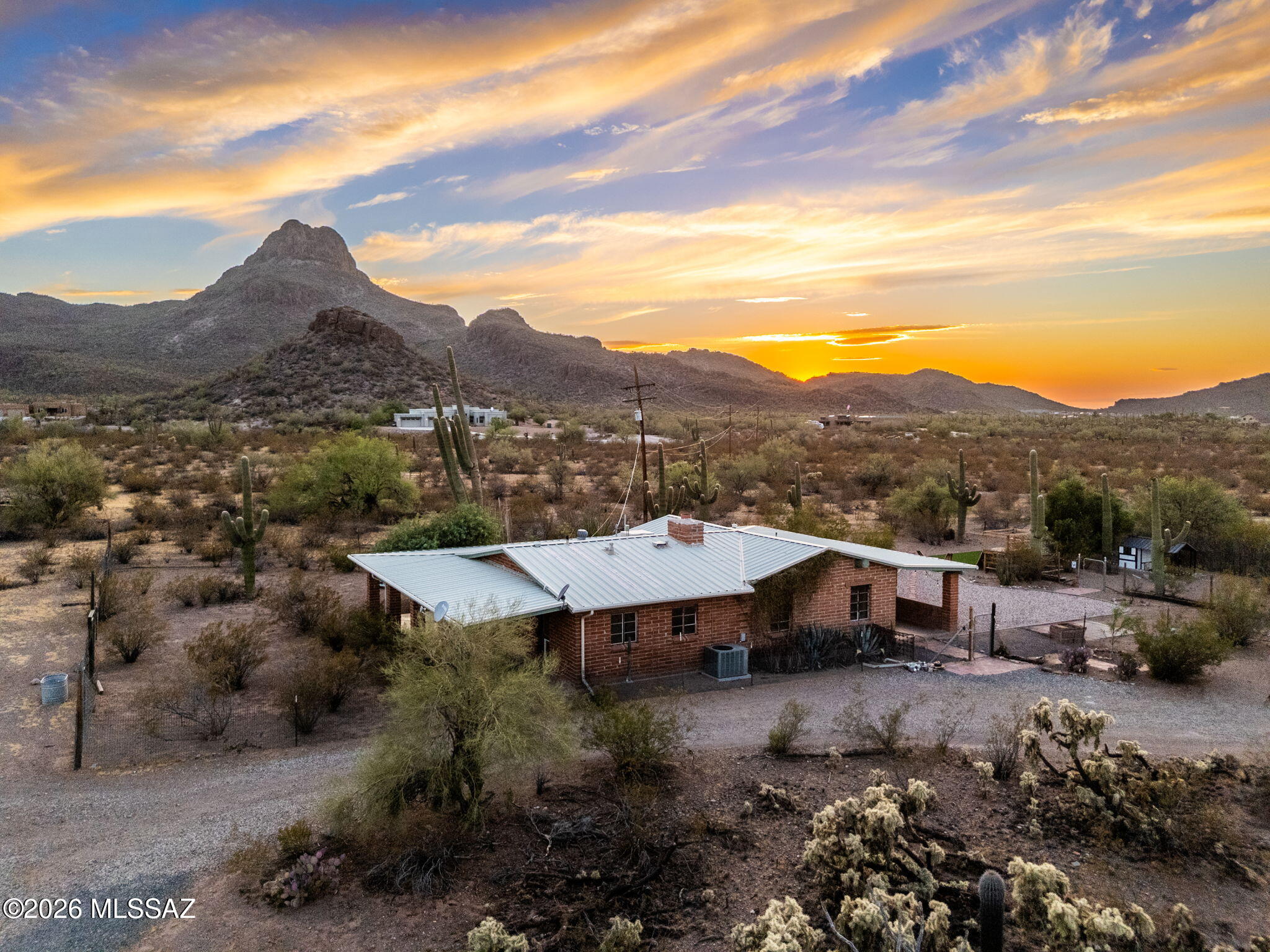 Step back in time with this one-of-a-kind Tucson area ranch property, where history meets modern rural living. The original structure dates to the Prohibition era and carries the storied rumor of having served as a speakeasy, giving this burnt adobe home a character no new construction could ever replicate. So notable was the property that it was featured in the November 1945 issue of Arizona Highways magazine. A later addition brought two bedrooms and two bathrooms, blending the old-world charm of the original build with everyday functionality.
Set on 5.7 fully field-fenced acres with no HOA and just steps away from Saguaro National Park West, Safford Peak Ranch is a true working property. The equestrian setup is exceptional, a five-stall barn with tack room (sink and power), a hay barn, a riding arena, and direct riding, running and mountain biking trail access into the national park make this a dream for horse and outdoor enthusiasts. Power was upgraded to 200-amp service in 2020, and a 50-amp RV outlet with well water hookup sits conveniently next to the barn where the former owns had their RV for guests. 
The property also features a separate garage, chicken coop, two raised-bed gardens (stock tank style with soil), and fruit trees including fig, lime, pineapple guava, pomegranate, Chinese jujube, mulberry, and Santa Rosa plum. A tractor is available for separate purchase.

Whether you're looking to run horses, homestead, or simply escape to a property with soul, Safford Peak Ranch delivers on all fronts.