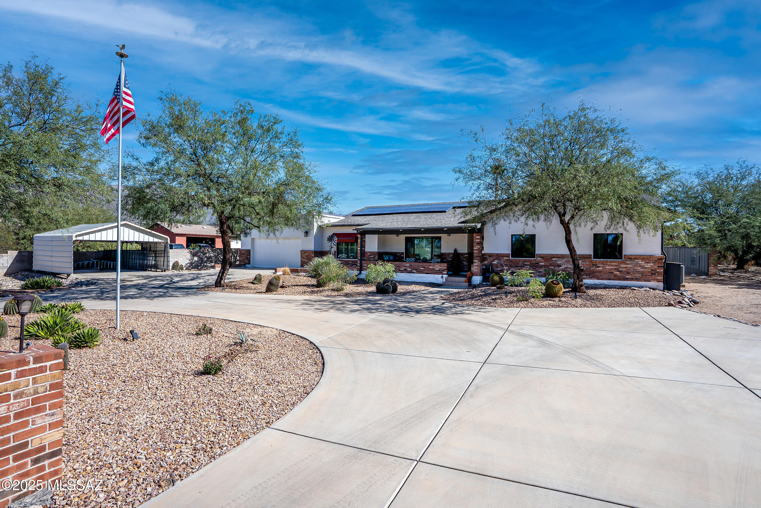 This stunning ranch-style home is situated on almost an acre of horse property in the desirable Tanque Verde valley!. Outstanding curb appeal with circular driveway & welcoming front sitting porch with views! Bright & spacious 2750 SF split bedroom/great room concept features 4 bedrooms, den, and 3 bathrooms. High ceilings throughout. Modern Farmhouse kitchen with spacious island, quartz countertops, and stainless steel appliances. Large primary suite with two walk in closets. Heated and cooled Arizona room with oversized windows off the patio provides additional living space (not included in square footage). Entertainer's backyard with Sparkling pool/spa/water feature, huge detached covered patio with built-in BBQ, bar, and seating with breathtaking mountain views! Continued--> The home is freshly updated with modern, yet warm, wood accents walls and mantel, open kitchen shelving, and bright open feel. Add in recessed lighting, and perfectly coordinated pendants and ceiling fans and this home is move-in ready. The laundry room even promises laundry will be fun with pops of Tiffany-hued color. Plantation shutters, Anderson windows throughout, OWNED solar, solid wood doors and trim, and abundant ceiling fans inside and out.
The beautiful backyard offers PebbleTec, solar-heated pool & spa, fire pit, large walled-in ramada which can be used for entertaining, and huge fenced  yard with 2 sets of double gates. Room for horses, animals, guest house, sport court, etc. And don't miss the bonus spacious workshop with electricity and storage shed - perfect for a tucked-away project/hobby room.