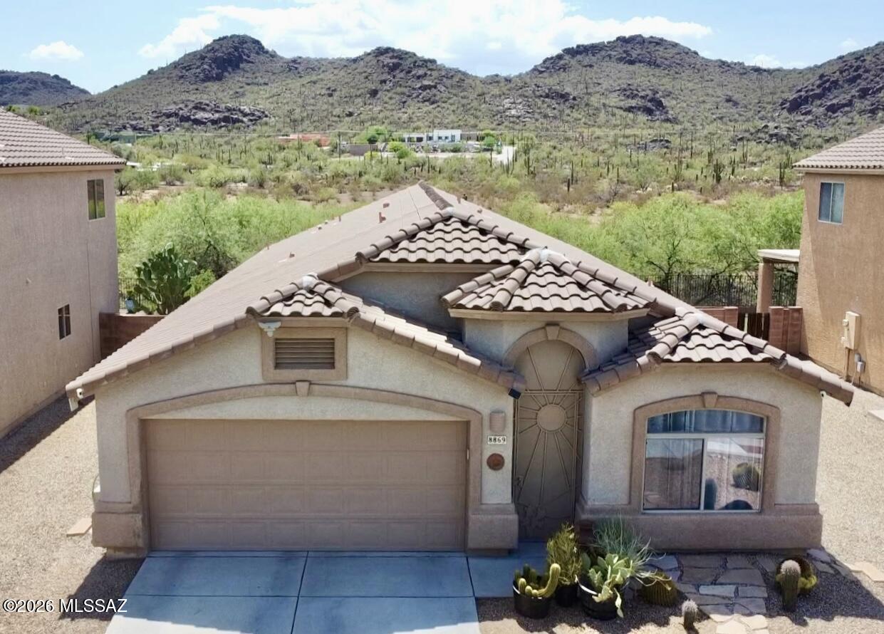 Stunning move-in-ready 4-bedroom home with breathtaking panoramic views of the Tucson Mountains and Safford Peak! Backing to a peaceful common area with no neighbors directly behind, this beautifully maintained home offers the perfect blend of comfort and Arizona desert beauty. Inside, enjoy an open and split bedroom floor plan with vaulted ceilings, ceramic plank tile, granite countertops, newer appliances, and a spacious primary suite with dual vanities and a walk-in tiled shower.  Updates include a new heating and cooling system (2024), new range (2023), and newer ceiling fans. Relax on the extended covered patio surrounded by low-maintenance landscaping and unforgettable sunset views. Community park, hiking trails, shopping, dining, and schools are just minutes away. Owner/Agent The kitchen also features cherry cabinetry, stainless steel appliances including oven with an air fryer feature, pull-out shelving, and abundant cabinet storage. Large windows provide excellent natural light throughout the home, and all secondary bedrooms are generously sized with spacious closets and access to the Jack and Jill bathroom. The backyard includes artificial turf and desert landscaping for easy maintenance while maximizing the serene desert setting. The private community park offers grassy areas, picnic tables, BBQ grills, and a playground, making it an ideal place to enjoy the neighborhood amenities. This meticulously maintained home offers quality finishes throughout and exceptional privacy with uninterrupted desert views beyond the common area.