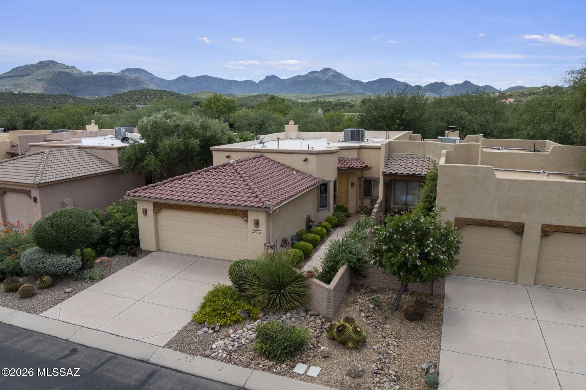 Experience the natural light, warm sunshine, and clear air of winter in Arizona with this easy-living, easy-to-maintain home featuring elegant spaces indoors and out. Walled backyard faces private common space with a picturesque water feature. Here you'll enjoy a covered patio for al fresco entertaining. Interior design details include architectural arches, tile flooring, kiva fireplace, seated passthrough, and an open-concept floorplan. Large eat-in kitchen features wood cabinetry, granite countertops, stainless steel appliances. Primary retreat offers direct patio access plus en suite bath with double-sink vanity and step-in shower. Flex space is configured for work-from-home office with built-in cabinetry. Don't miss the double-bay attached garage for added convenience.